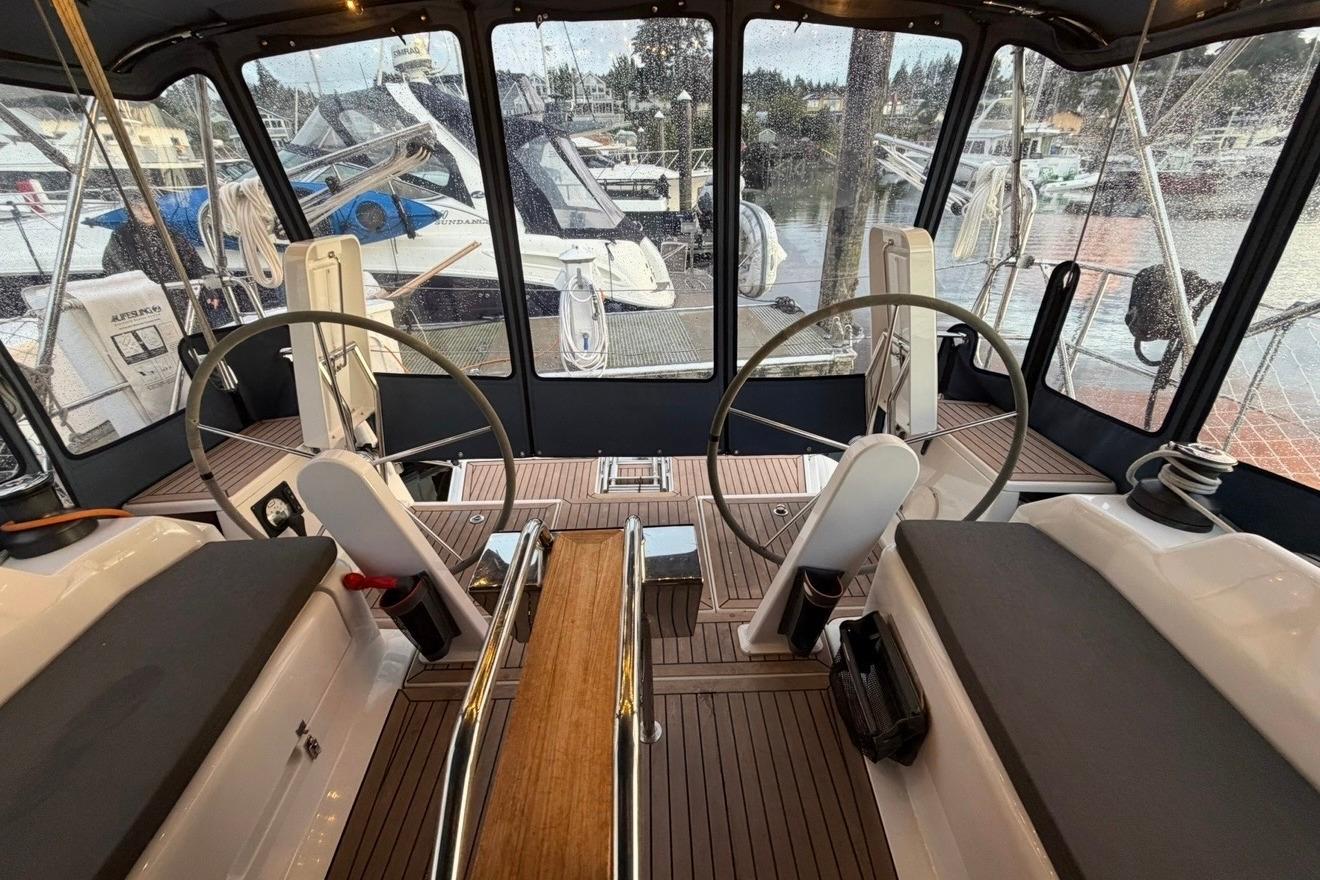 Interior view of 2022 Hanse 418 yacht cockpit with dual steering wheels.