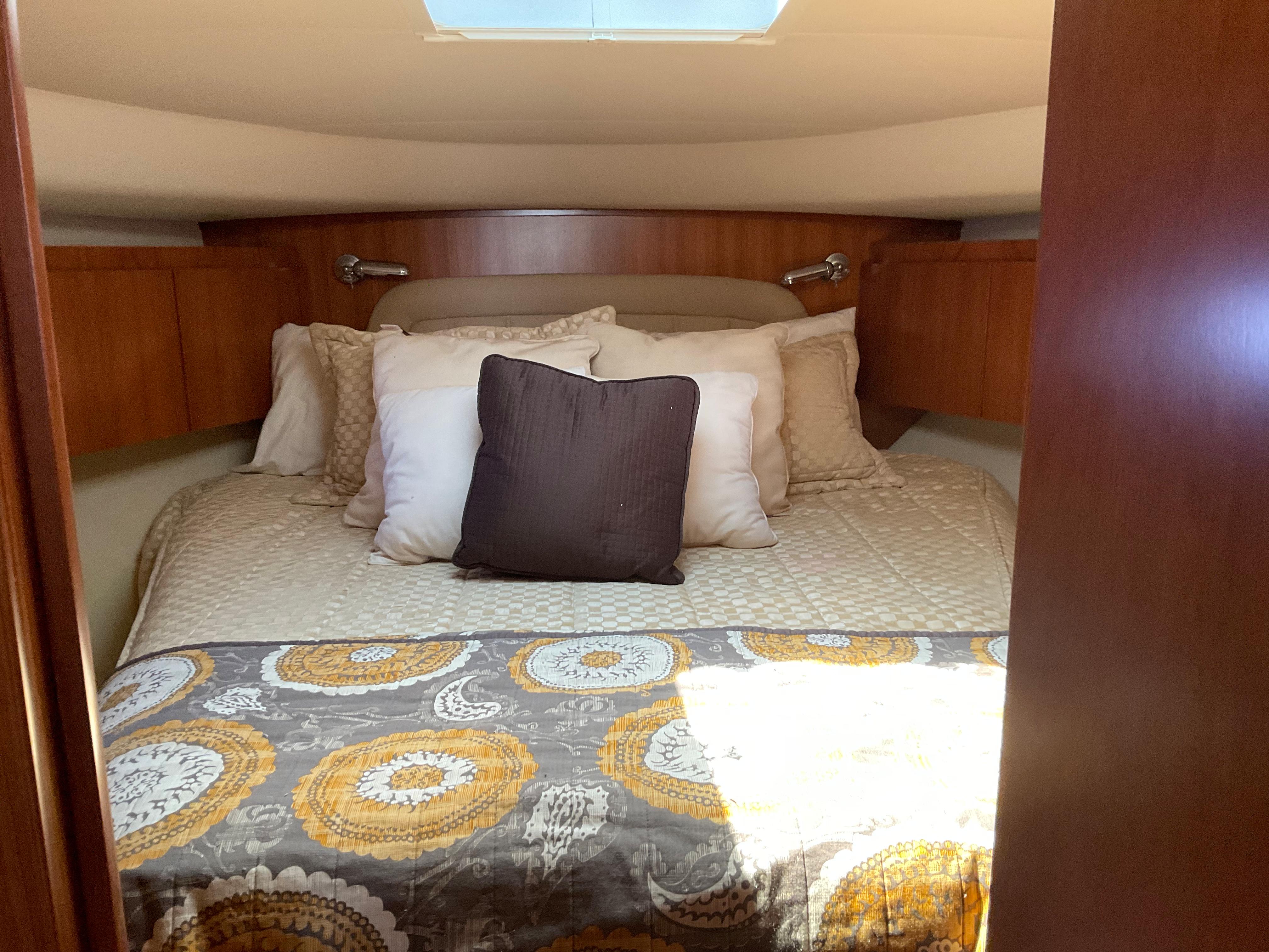 Luxurious cabin interior of 2004 Tiara Yachts 4400 Sovran with cozy bedding.