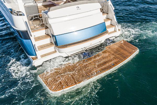 2021 Riviera 5400 Sport Yacht rear view with swim platform in water.
