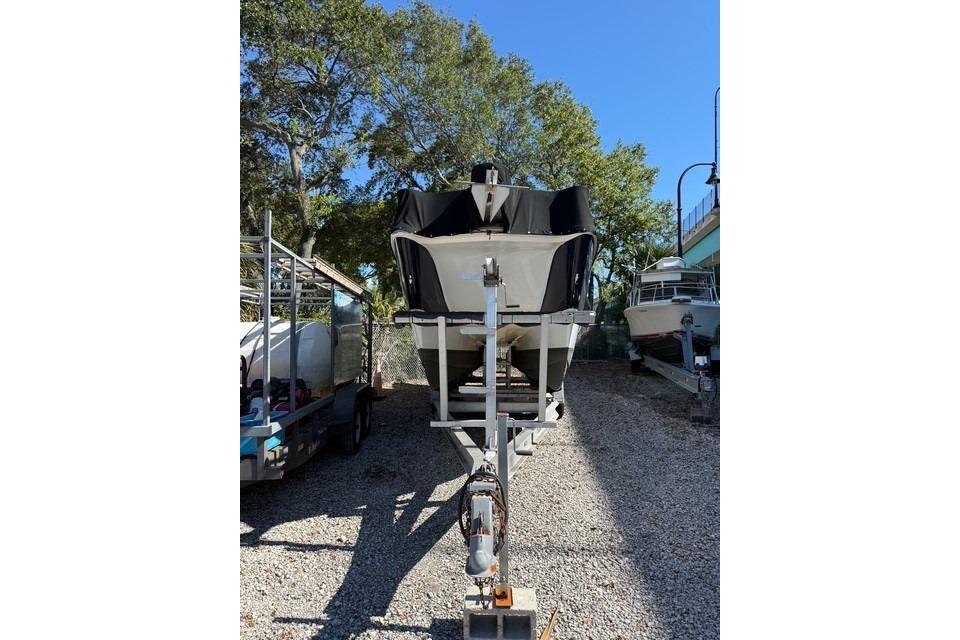 2003 World Cat 270 EC boat on trailer, parked outdoors under clear sky.