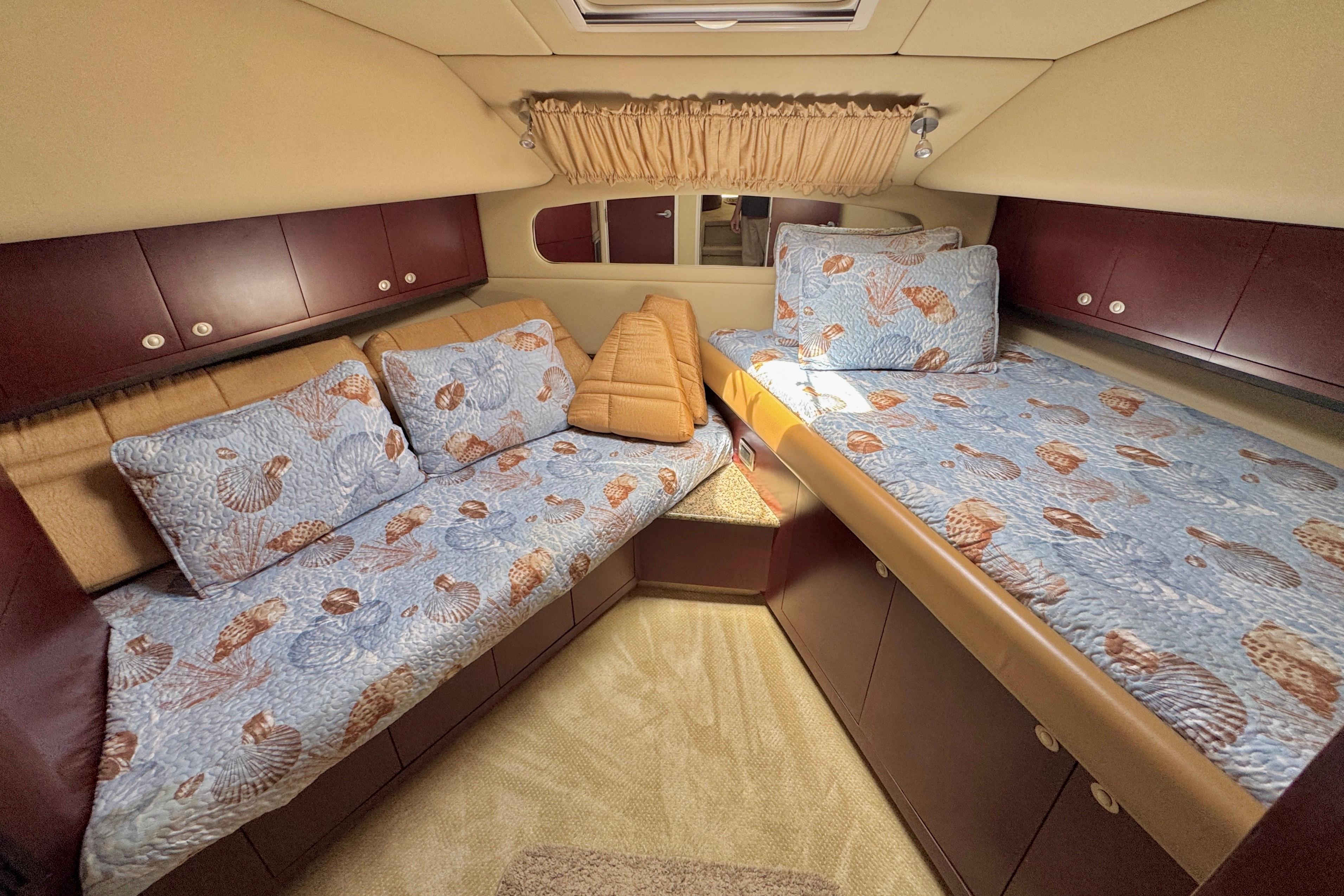 2006 Sea Ray 40 Motor Yacht cabin with seashell-themed bedding and wooden cabinetry.