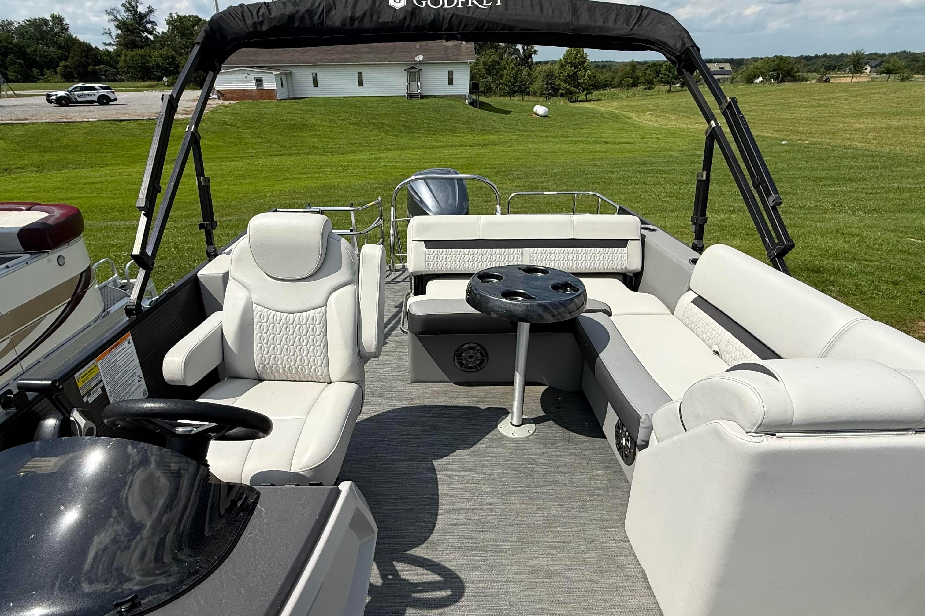 Interior of 2022 Godfrey SWEETWATER 2486 pontoon boat with plush seating and table.