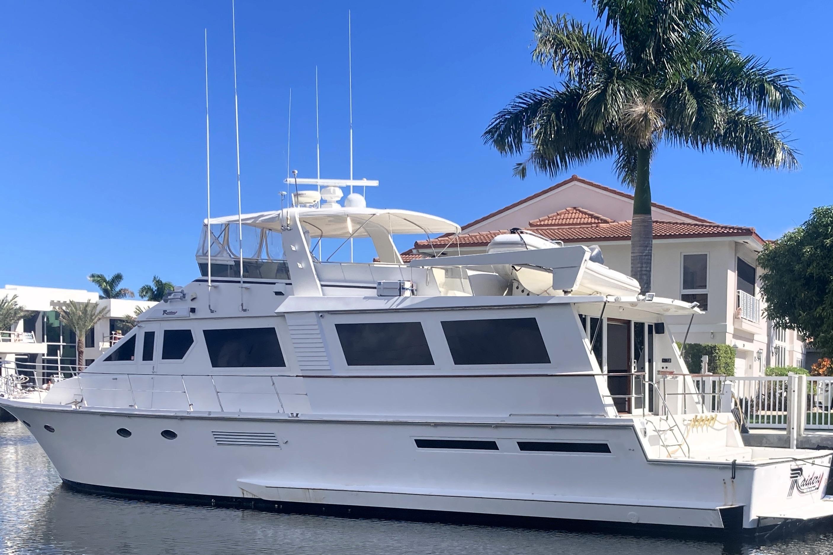 1988 Viking 70 Cockpit Motor Yacht docked near palm trees and waterfront homes.