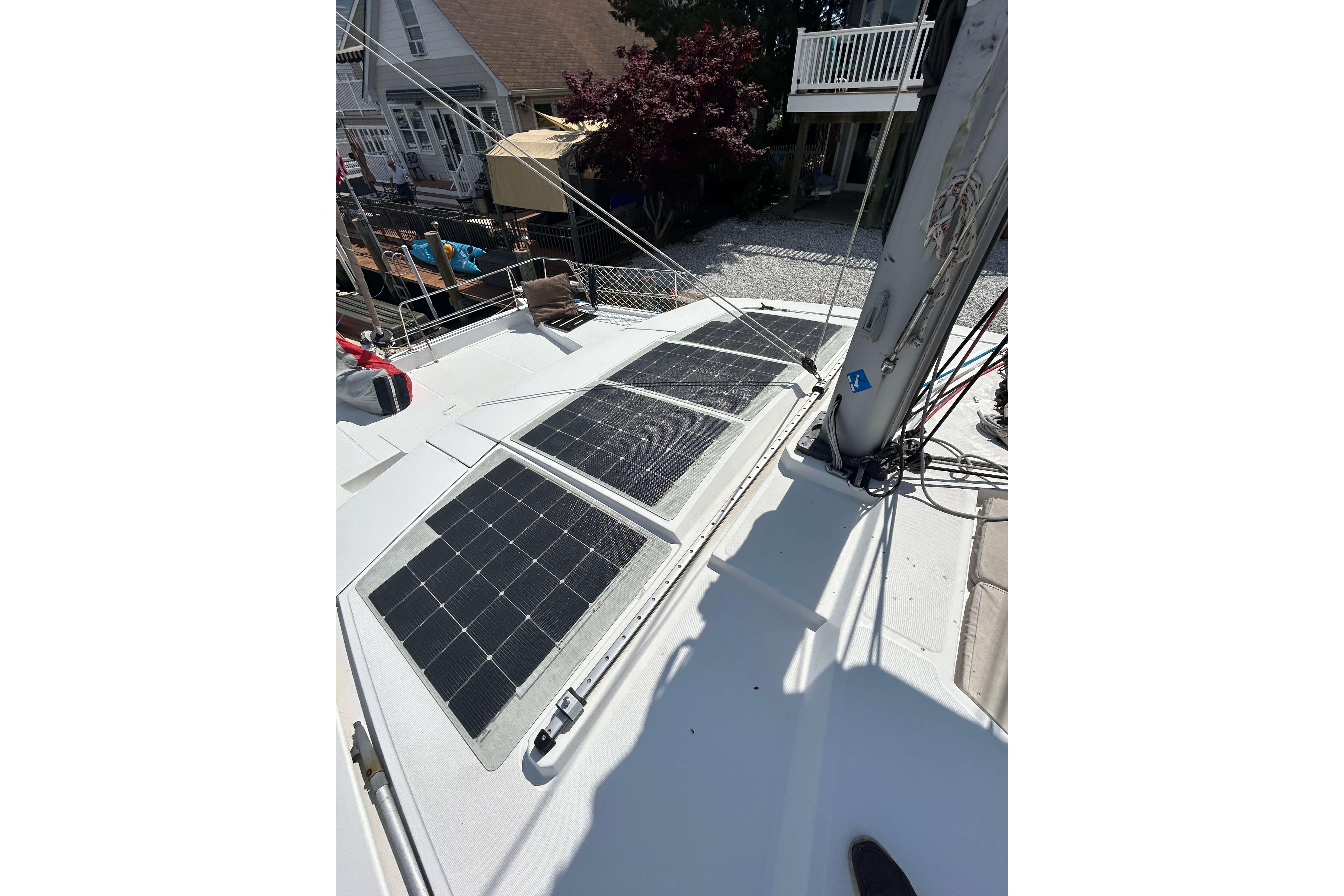 Solar panels on a 2018 Bali 4.1 catamaran deck, docked near residential area.