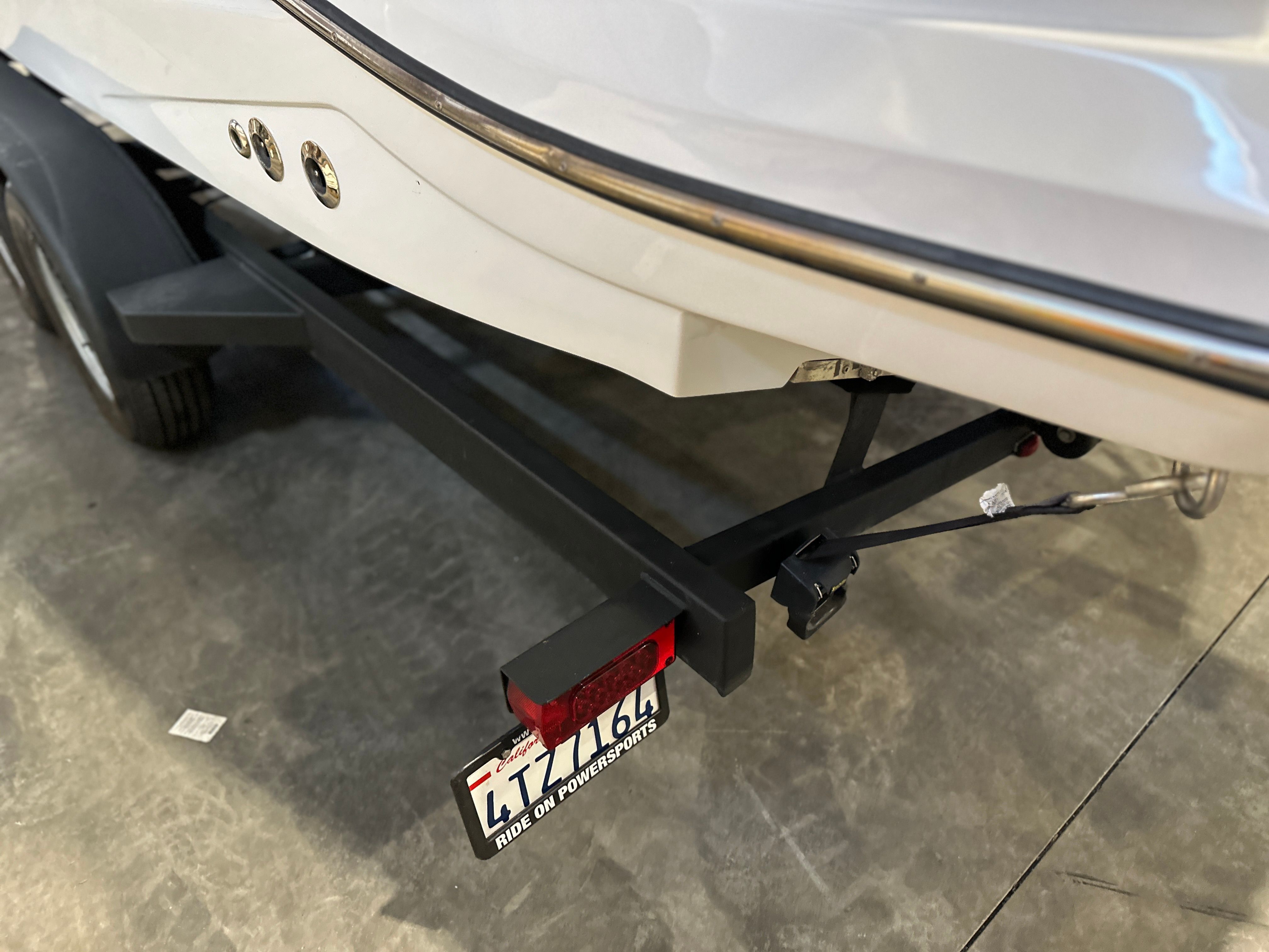 Close-up of a boat's stern on a trailer in a garage.