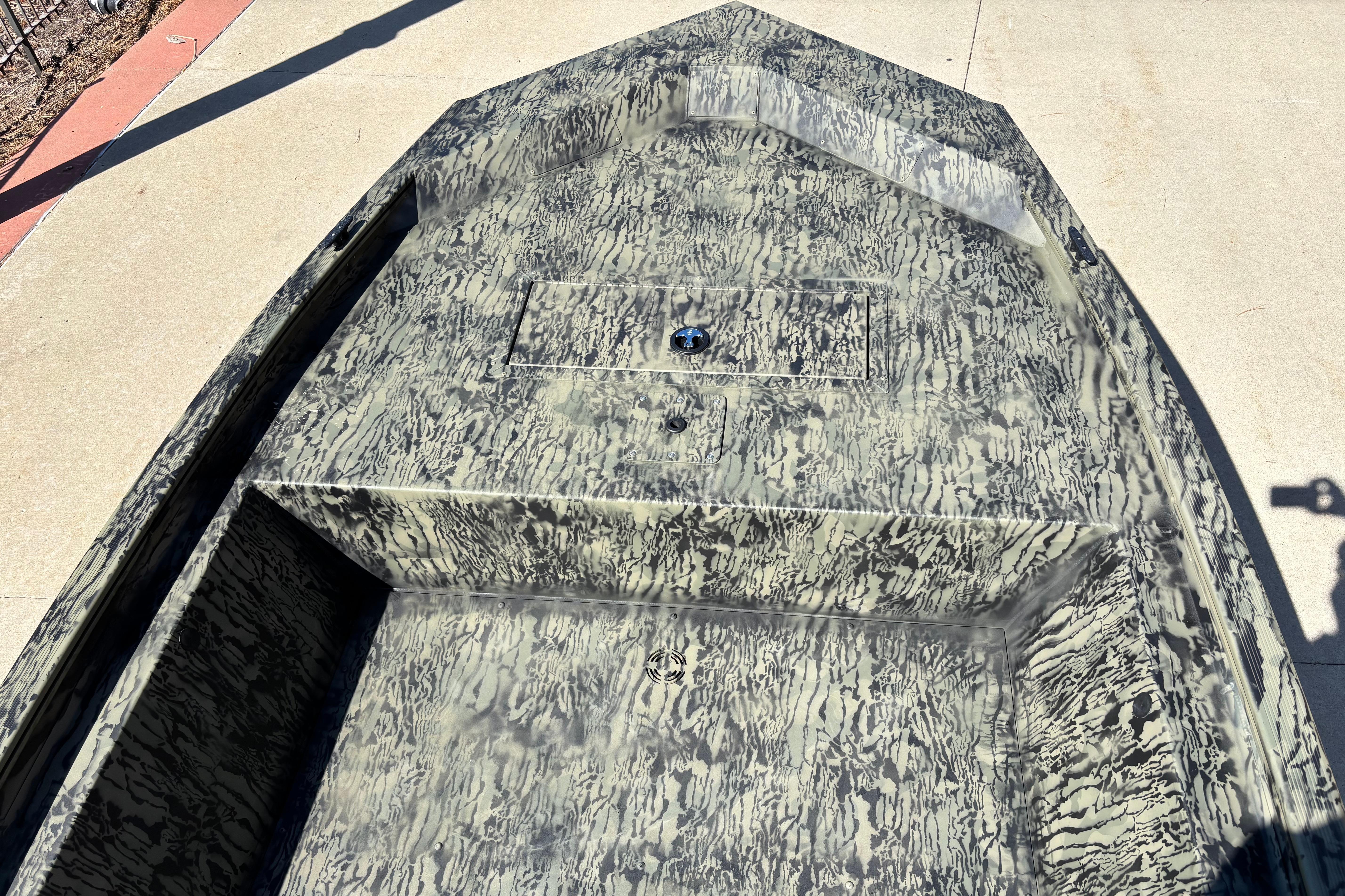 2026 Tracker Grizzly 1648 Utility boat with camouflage pattern on concrete surface.
