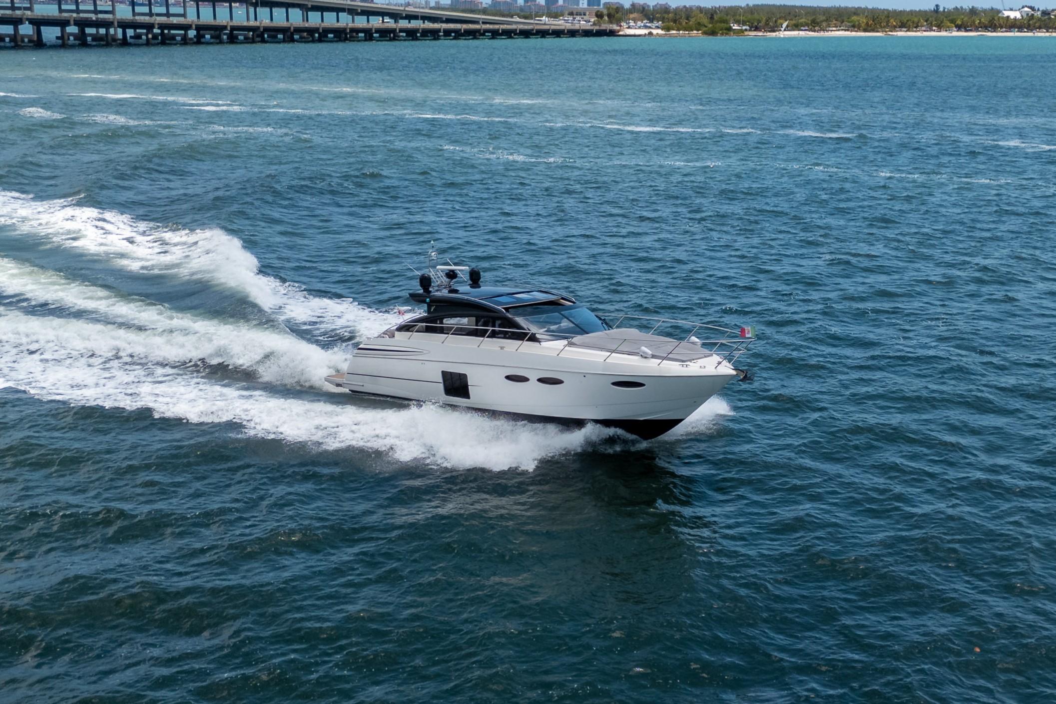 2012 Princess V52 yacht cruising on open water, creating a dynamic wake.