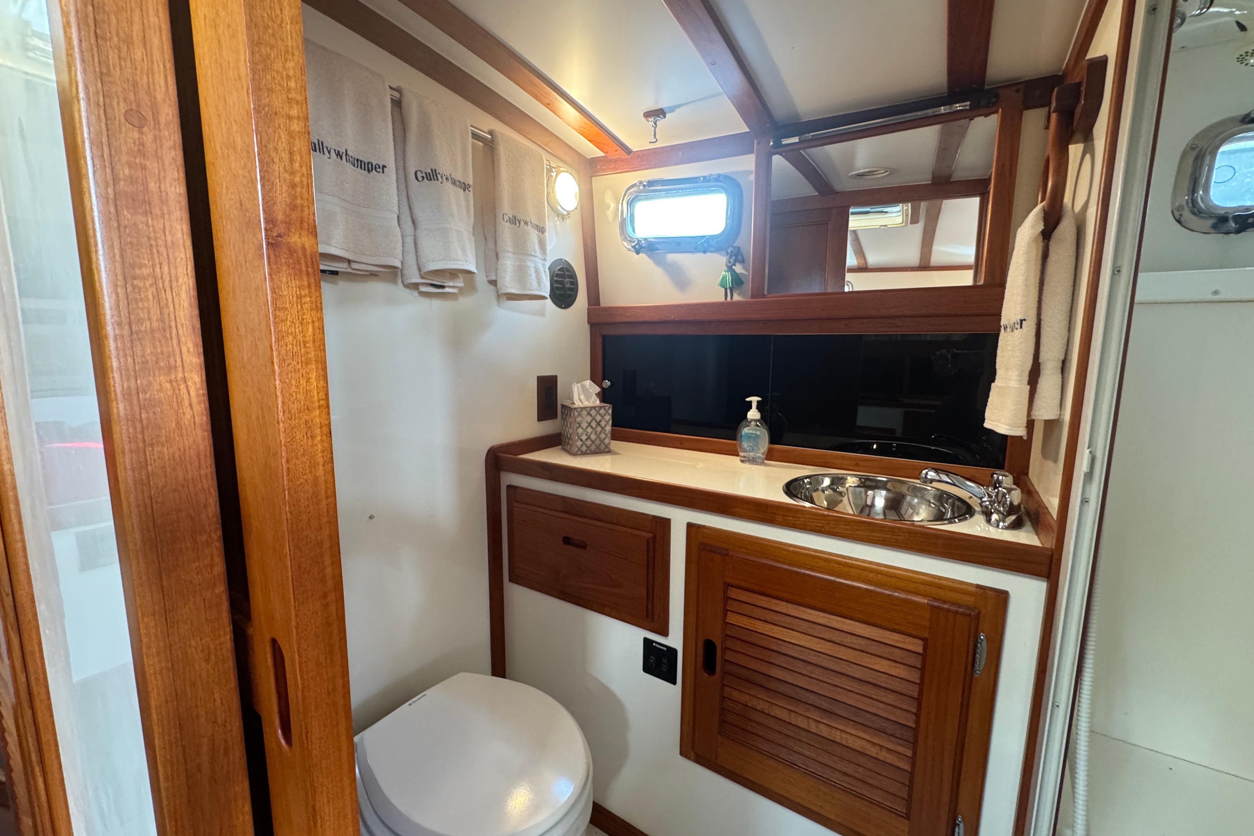 Luxurious bathroom interior of 2001 Ellis 36 Flybridge yacht with wooden accents and modern amenities.