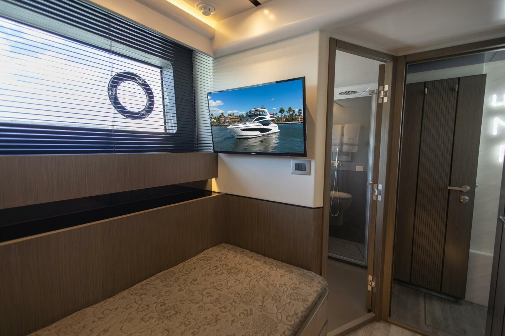 Luxurious interior of 2023 Pearl 72 yacht with TV and modern bathroom.