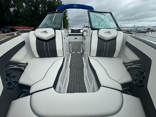 2018 Monterey 258 Super Sport boat interior with white and black seating, docked by trees.
