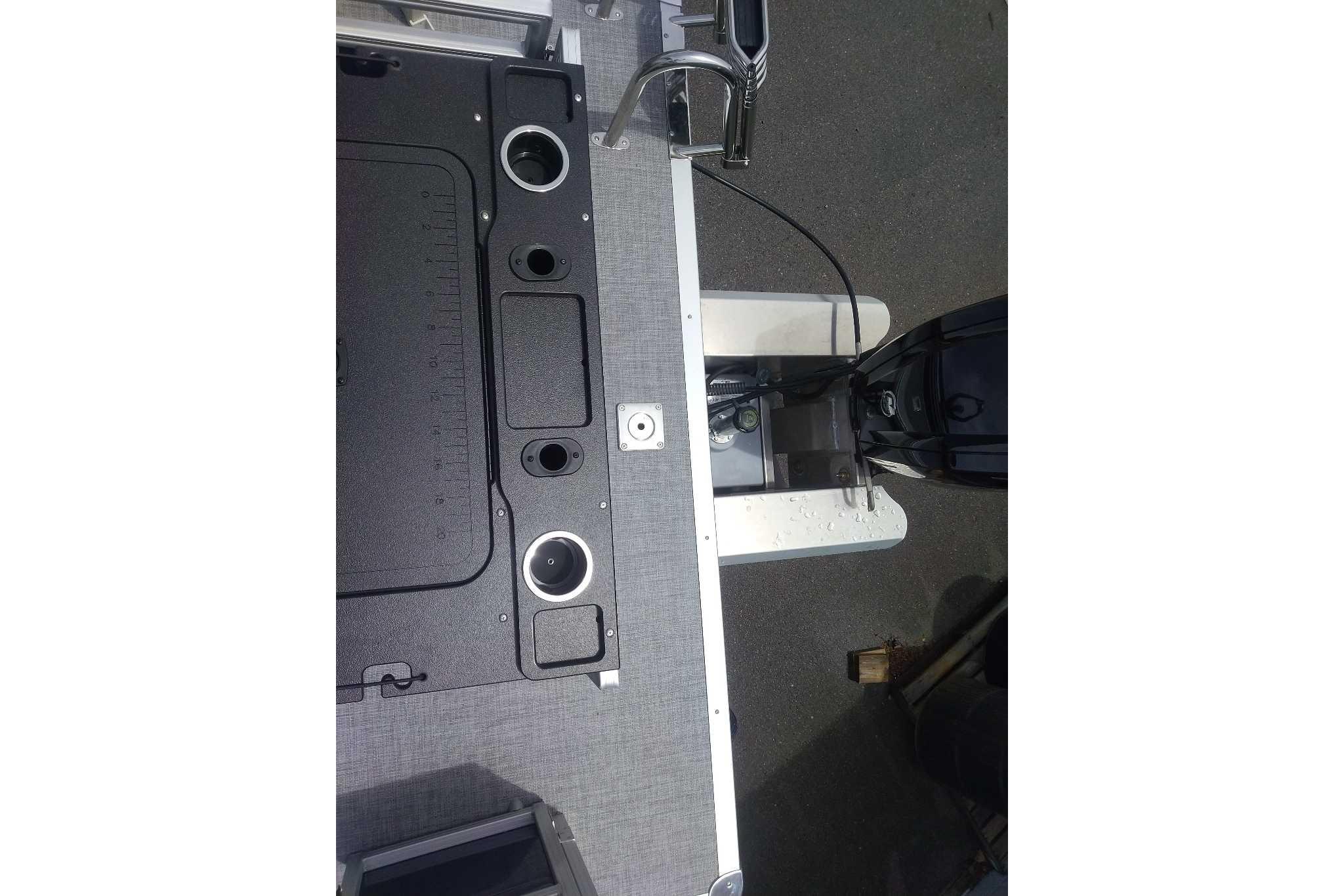 2026 Sun Tracker SportFish 20 DLX boat deck with motor and cup holders.