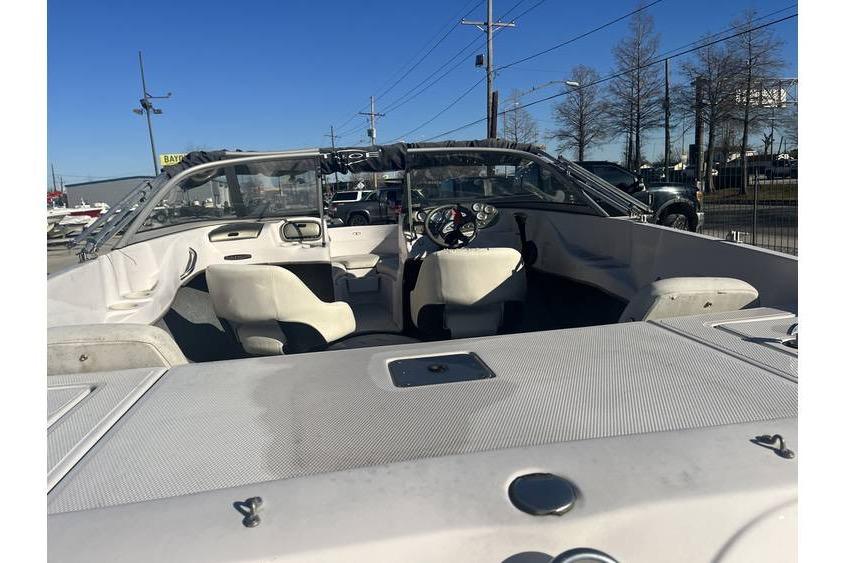 2006 Tahoe 206 boat interior with steering wheel and seating under clear blue sky.
