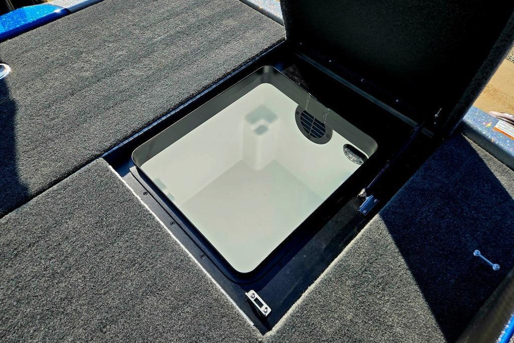 Open storage compartment on 2026 Skeeter ZXE20 boat with carpeted flooring.