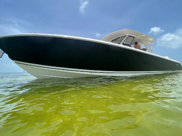 2019 Pursuit S 408 Sport boat on clear water under blue sky.