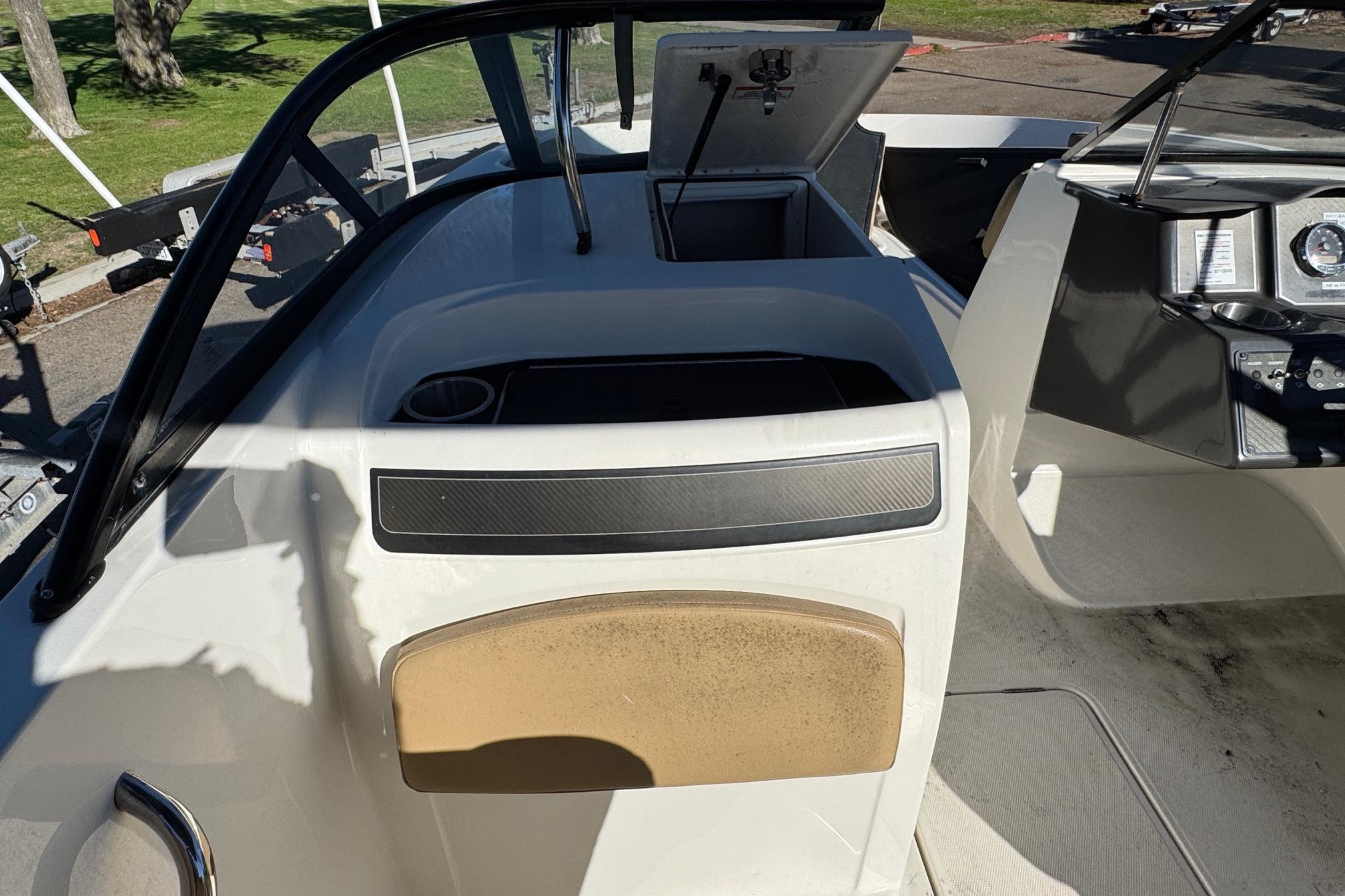 2022 Bayliner VR6 Bowrider OB interior with open storage compartment and dashboard view.