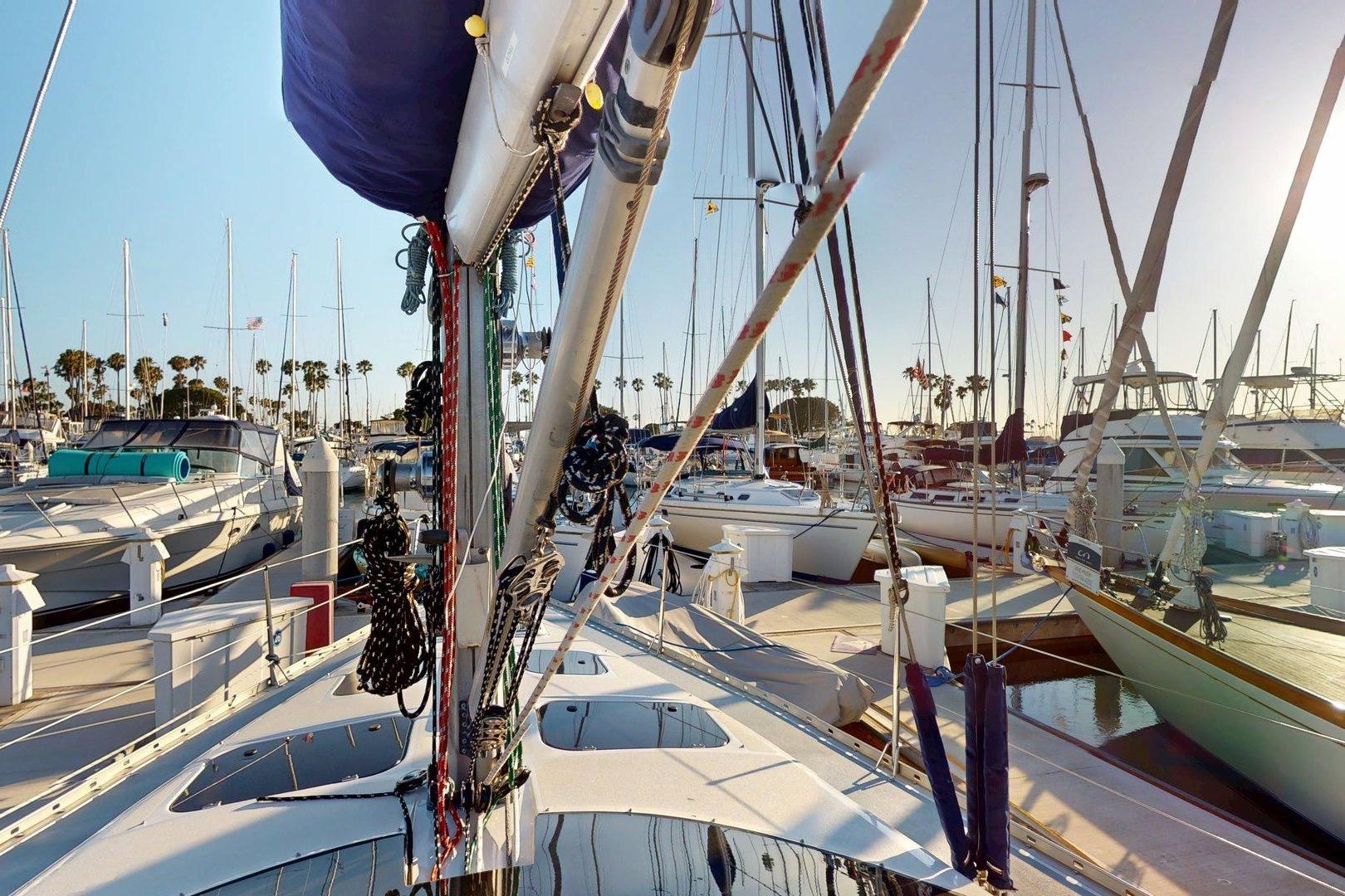 1997 Hunter Legend 40.5 sailboat docked in a sunny marina with palm trees.