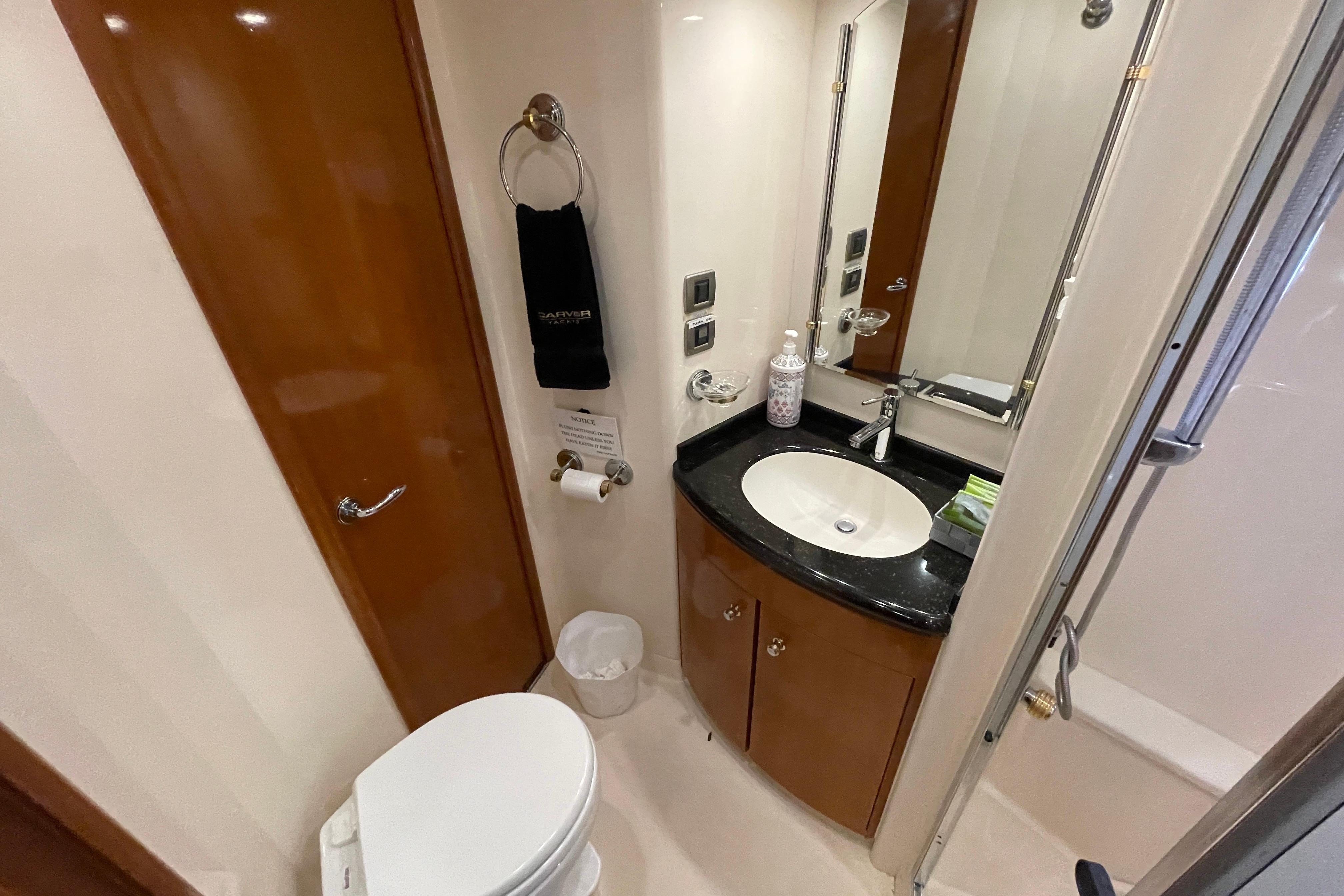 Bathroom interior of 2002 Carver 570 Voyager Pilothouse with sink, toilet, and shower.