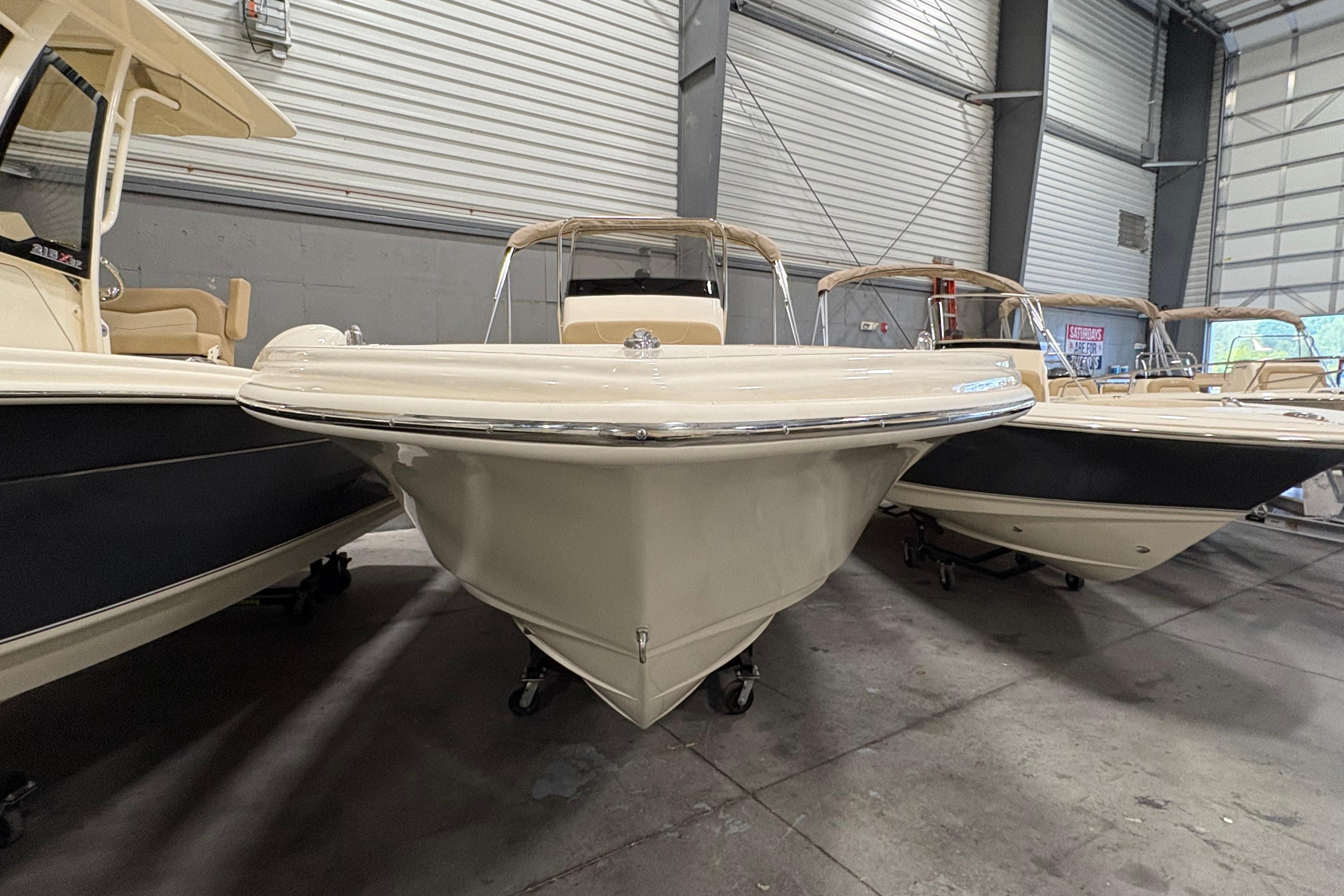 2025 Scout 215 XSF boat in showroom, front view, beige color, indoor display.