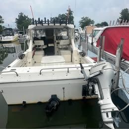 A 2001 Sport-Craft 272 boat is docked in the water, surrounded by other boats.