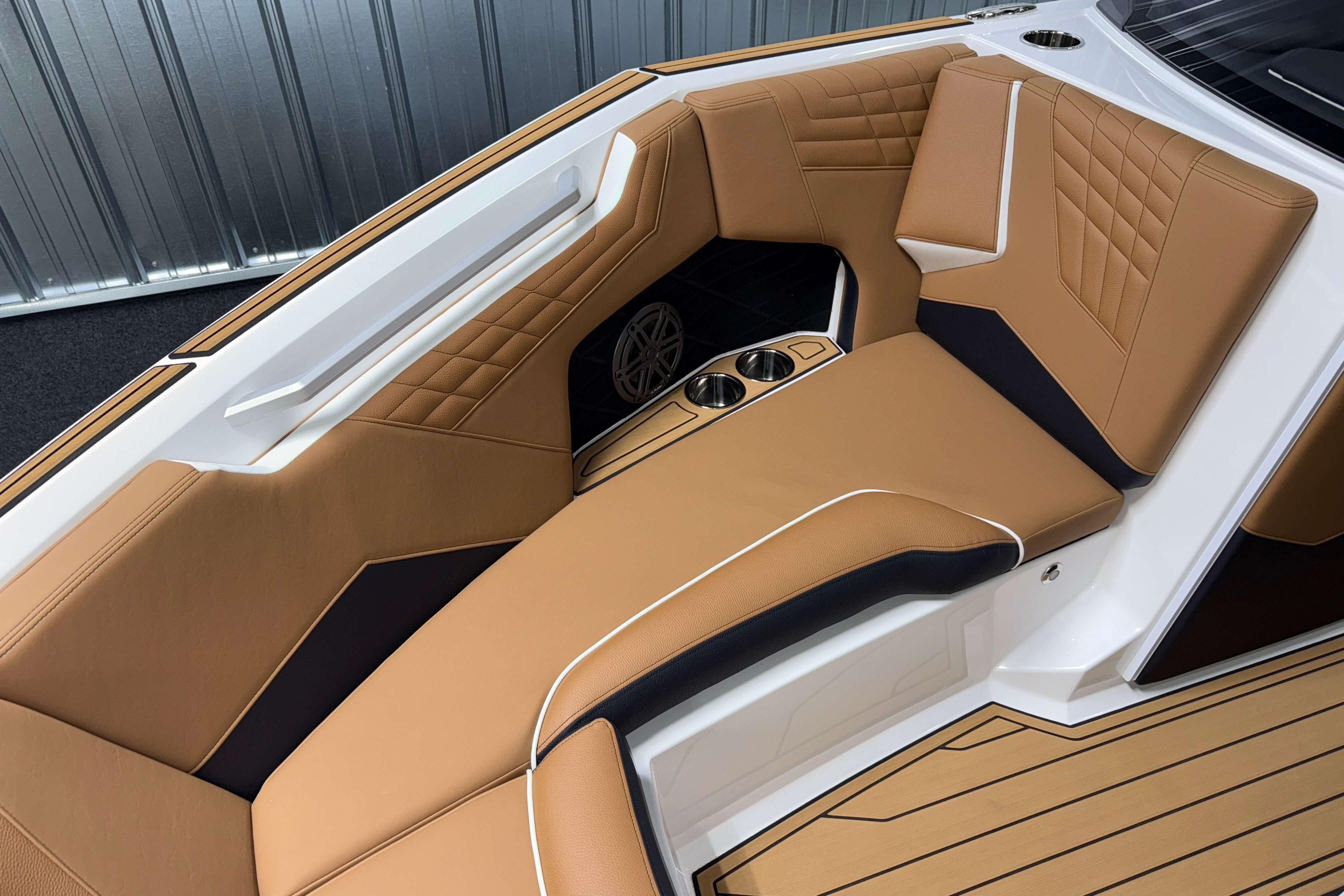 2026 Nautique Super Air Nautique S23 interior with tan leather seating and cup holders.