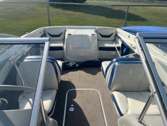 2005 Bayliner 205 Bowrider interior with white and blue seating, open bow design.