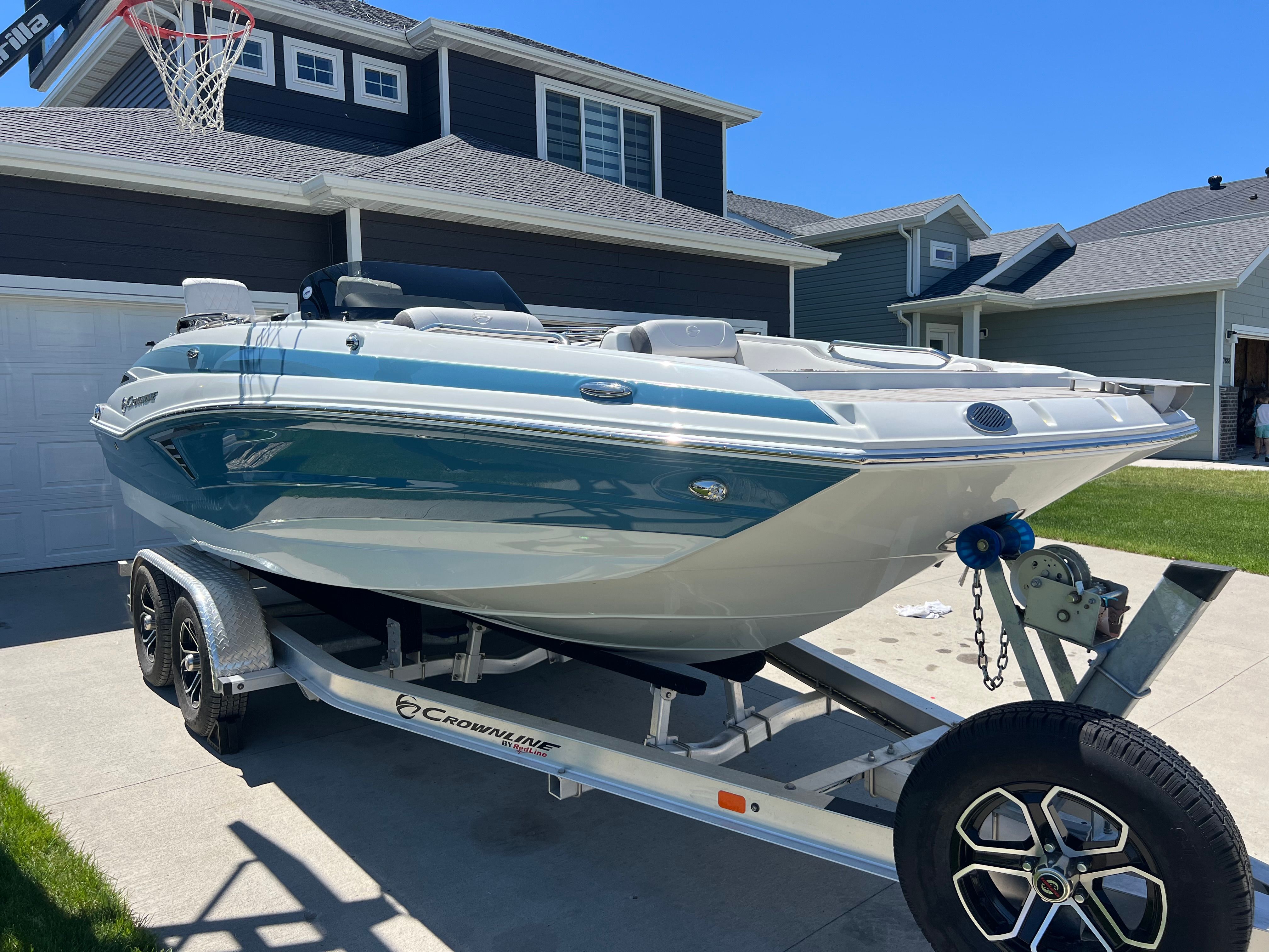 2024 Crownline Eclipse E210 XS boat on trailer in driveway.
