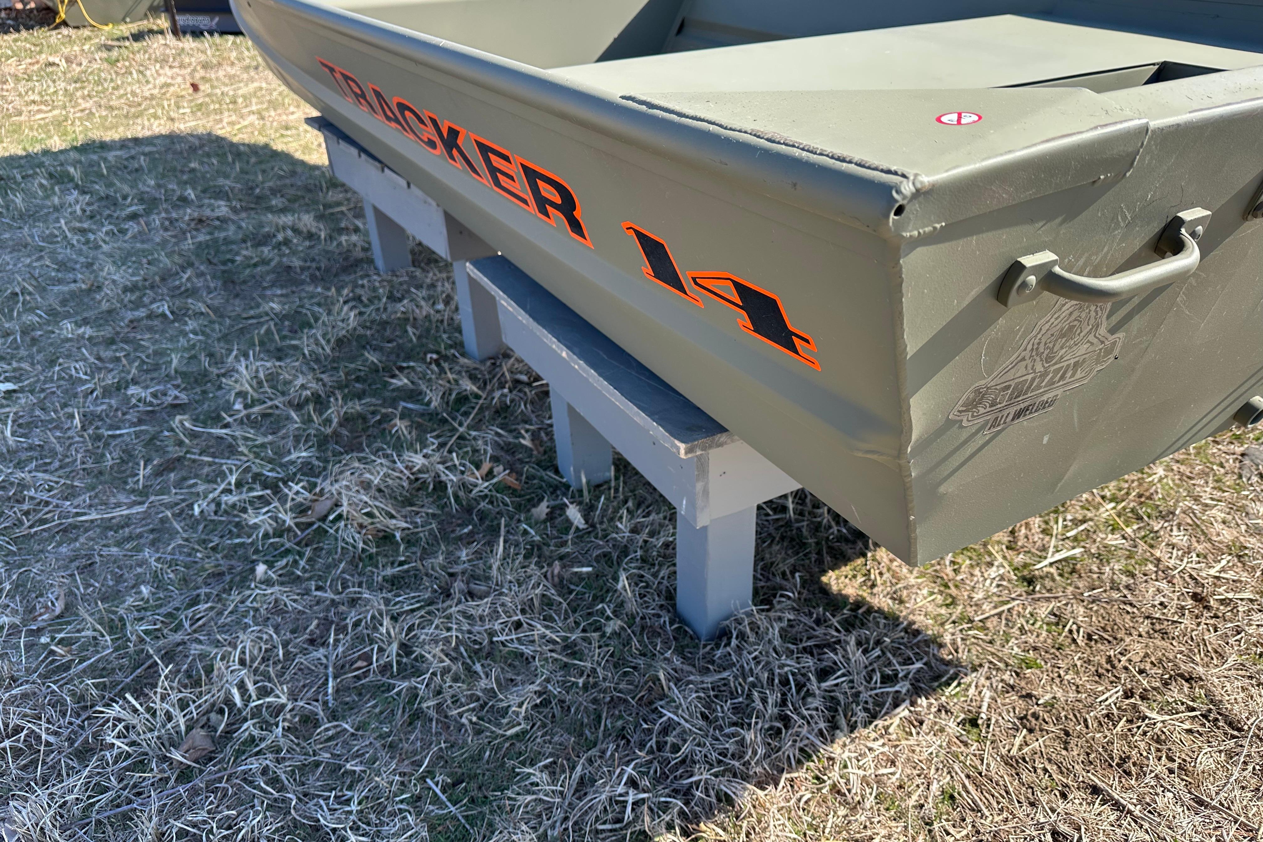 2026 Tracker Grizzly 14 Jon boat on grass, showcasing rear design and branding.