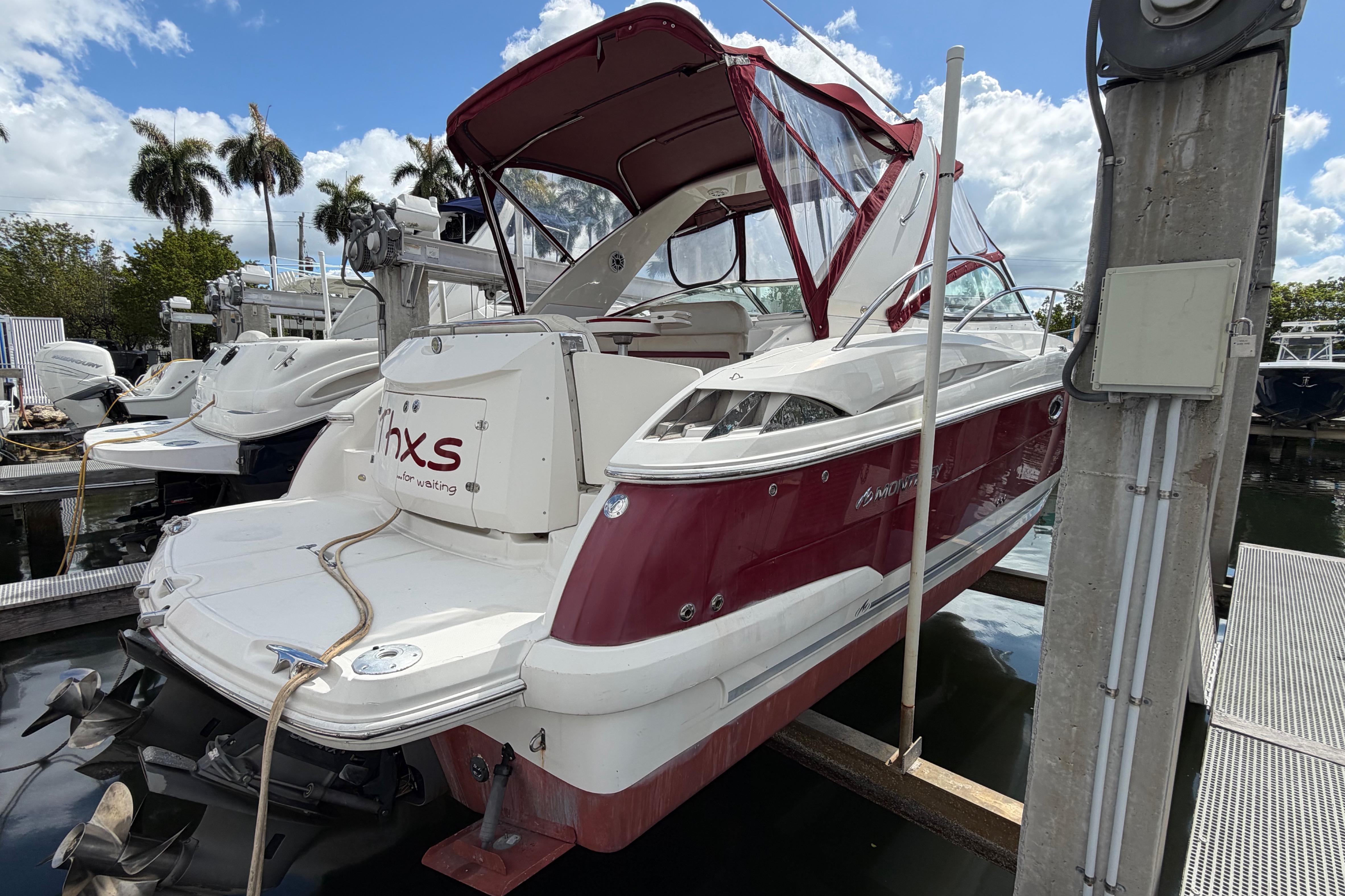2007 Monterey 350 Sport Yacht docked, featuring red and white exterior with canopy.
