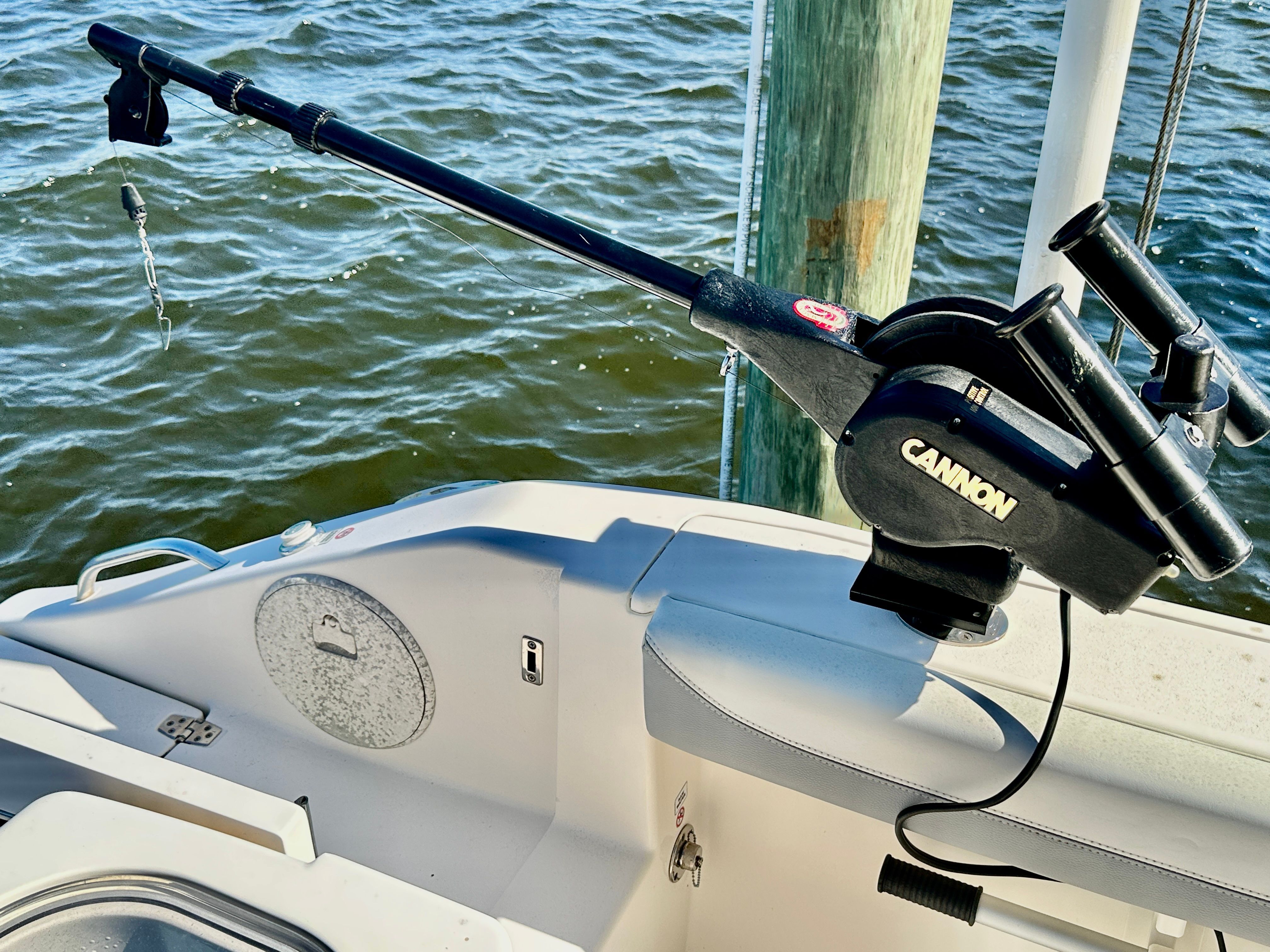 Fishing rod on a Cobia 240 Center Console boat docked by the water.