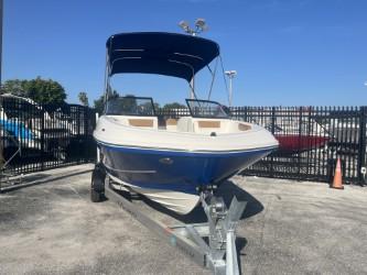 2022 Bayliner VR6 boat on trailer, blue hull, parked outdoors.
