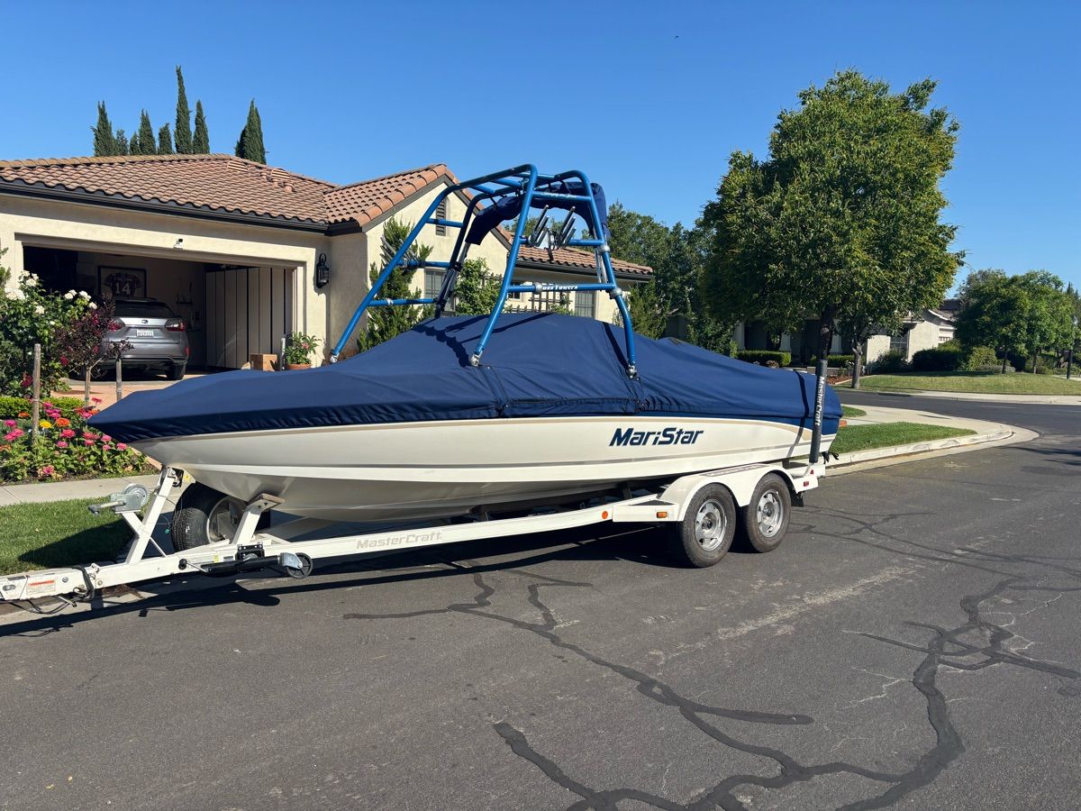 A 2000 MasterCraft MariStar 210 on a trailer in a residential area.