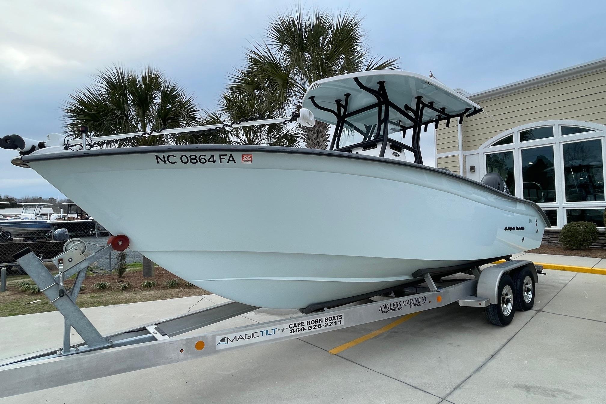 2023 Cape Horn 24 XS boat on trailer, parked near palm trees and building.
