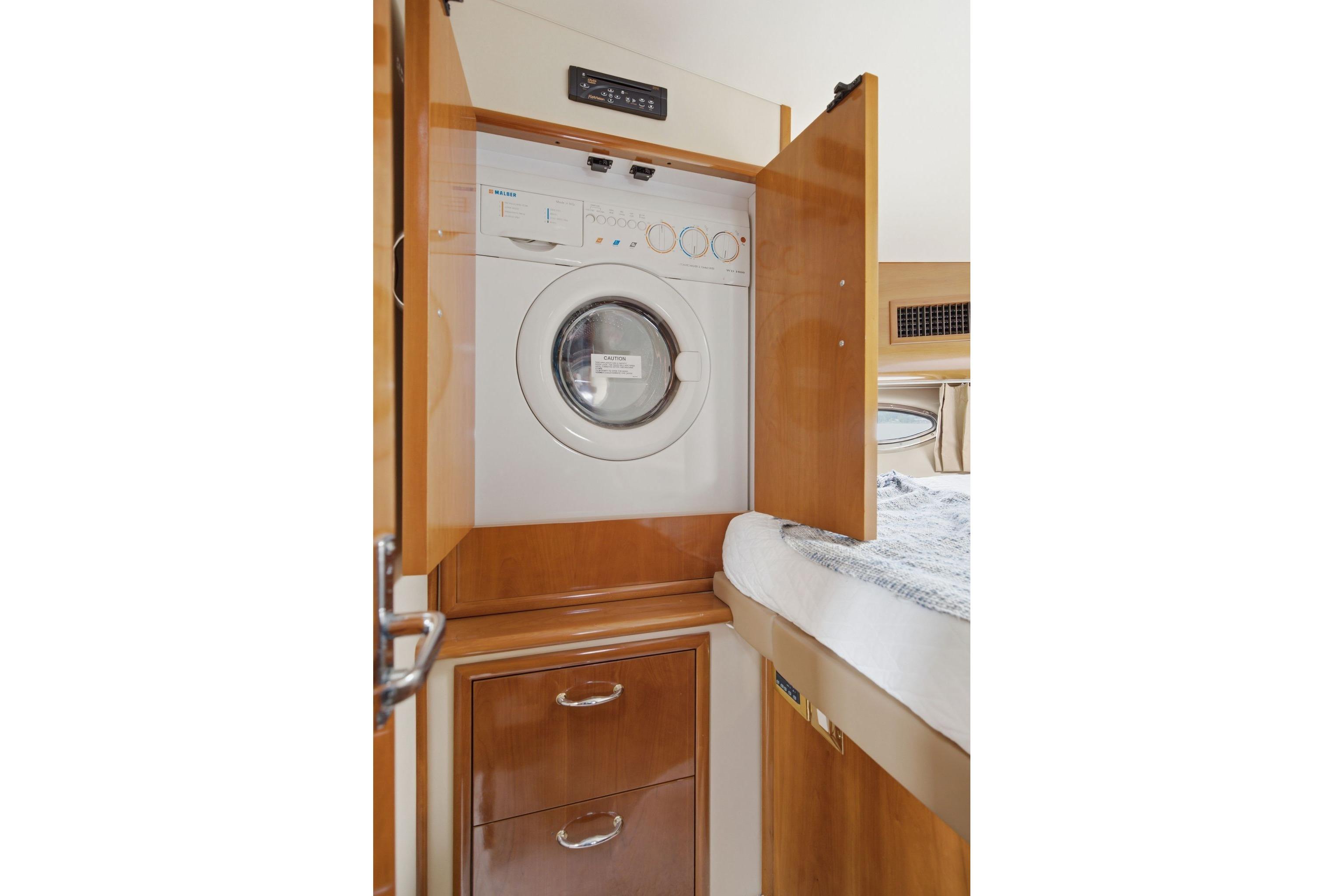 Laundry area inside 2005 Carver 39 Motor Yacht with washer and storage cabinets.