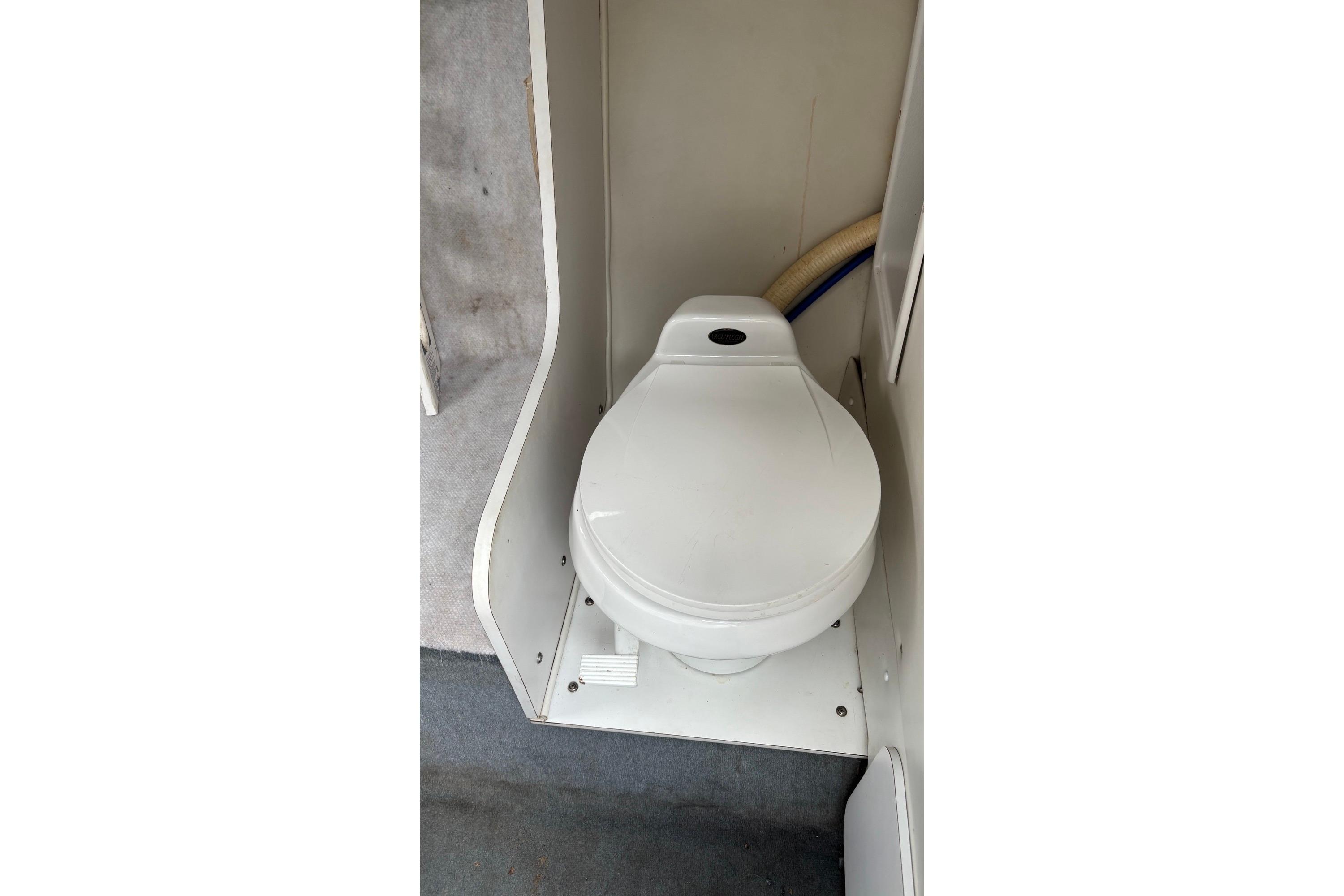 2002 Wellcraft 24 Walkaround boat interior with compact marine toilet.