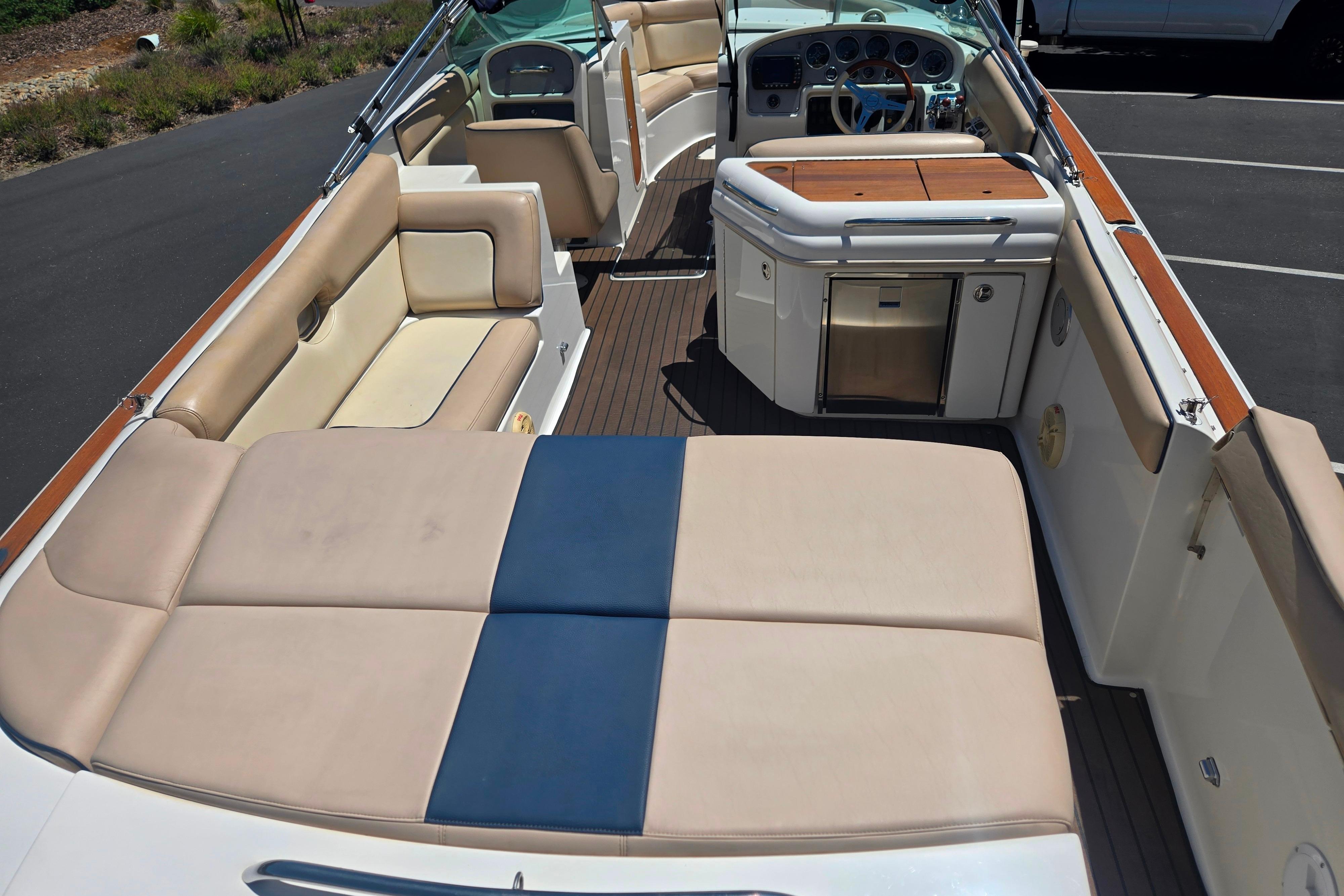 2002 Chris-Craft Launch 28 GT I/O boat interior with beige seating and wooden accents.
