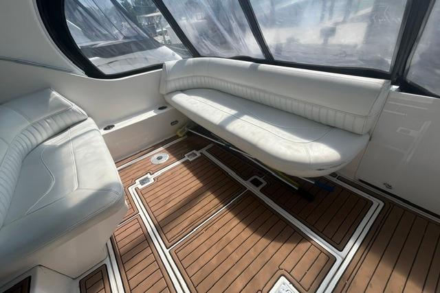 2004 Cruisers Yachts 3372 Express interior with white seating and wooden flooring.