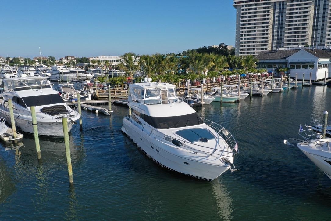 2005 Neptunus 56 Flybridge yacht docked at a marina with surrounding boats.