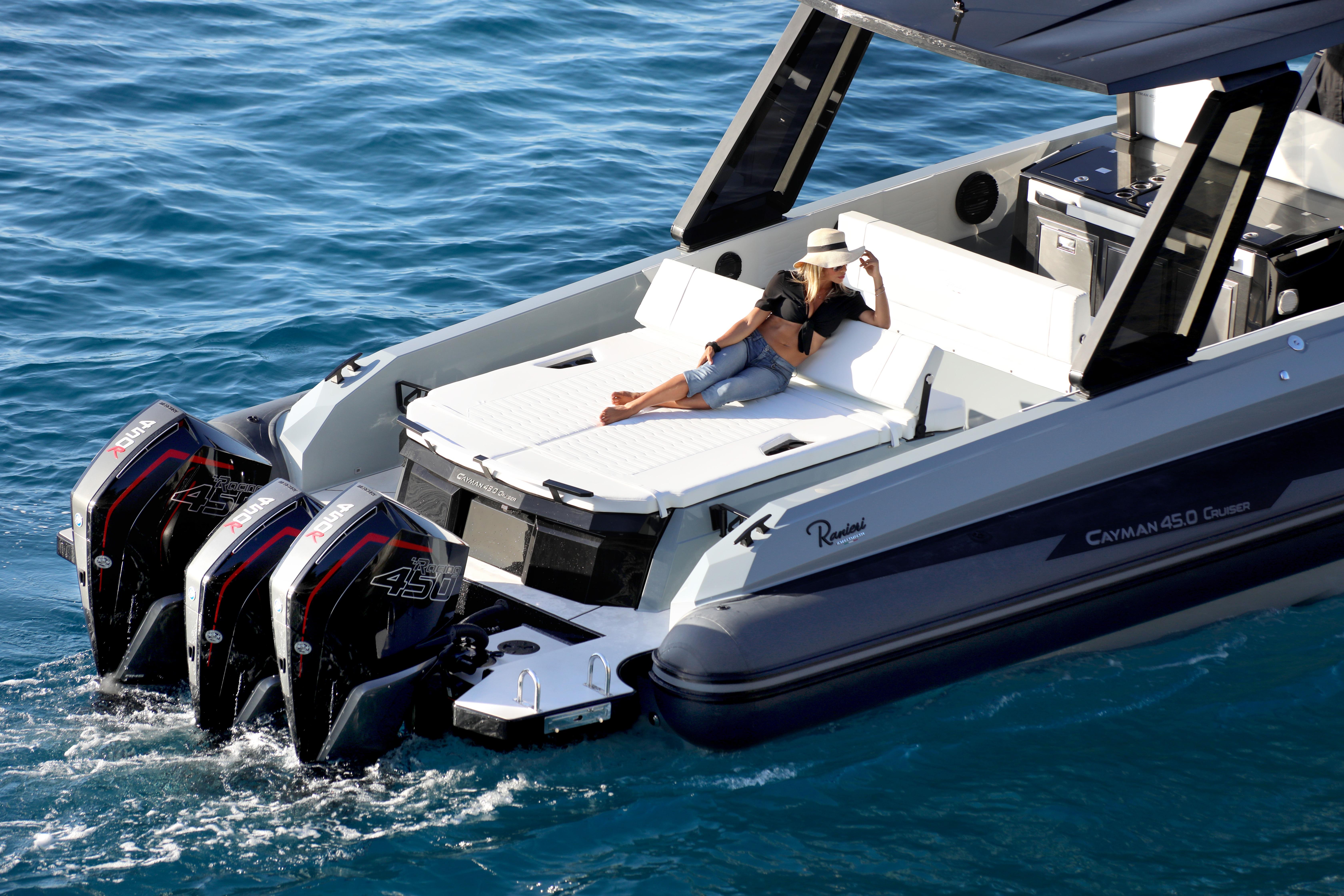 Luxury Ranieri CAYMAN 45.0 Cruiser 2026 with triple engines, woman relaxing on deck.