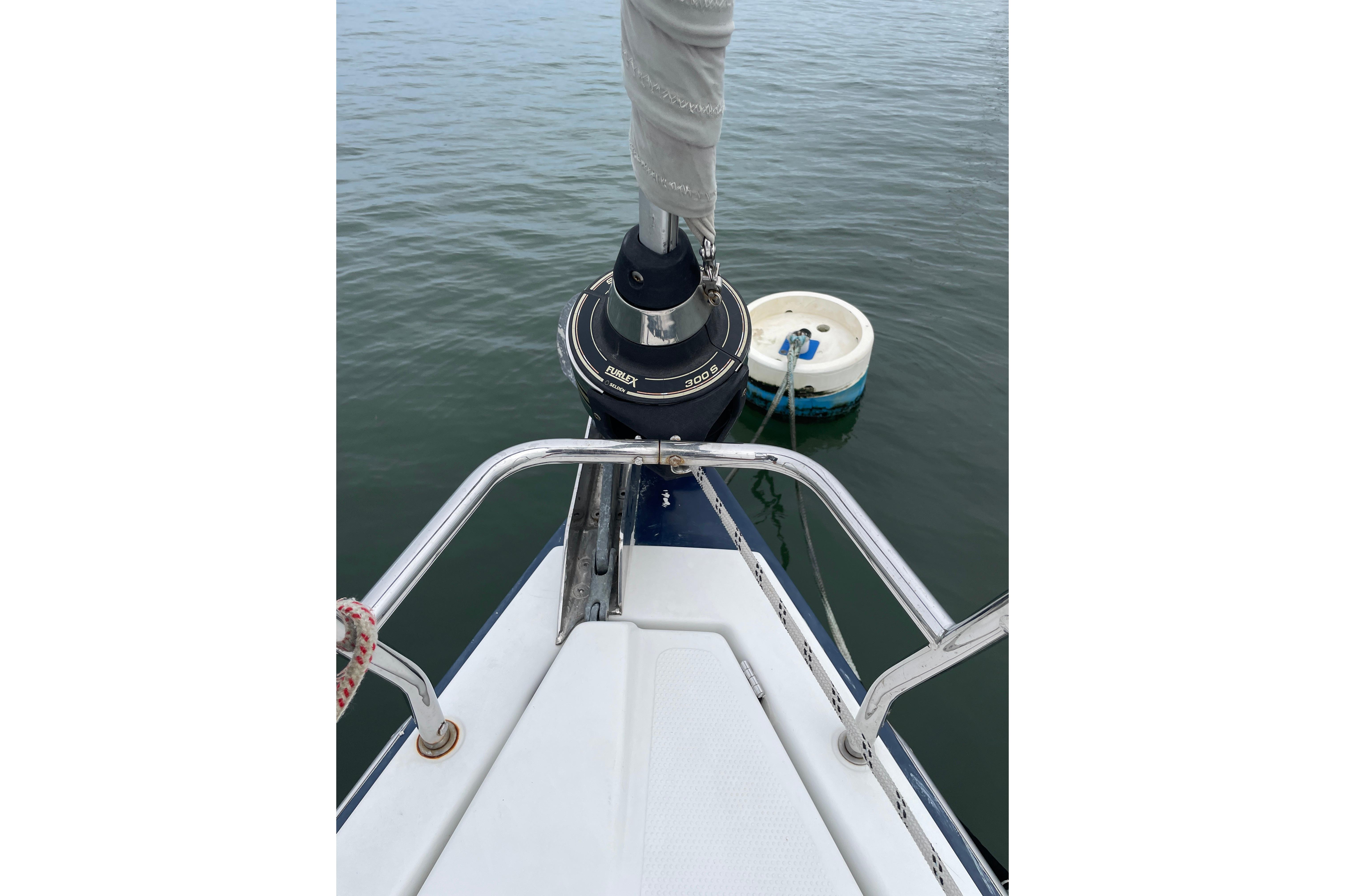 Bow of 2014 Hanse 415 yacht with mooring buoy in calm water.
