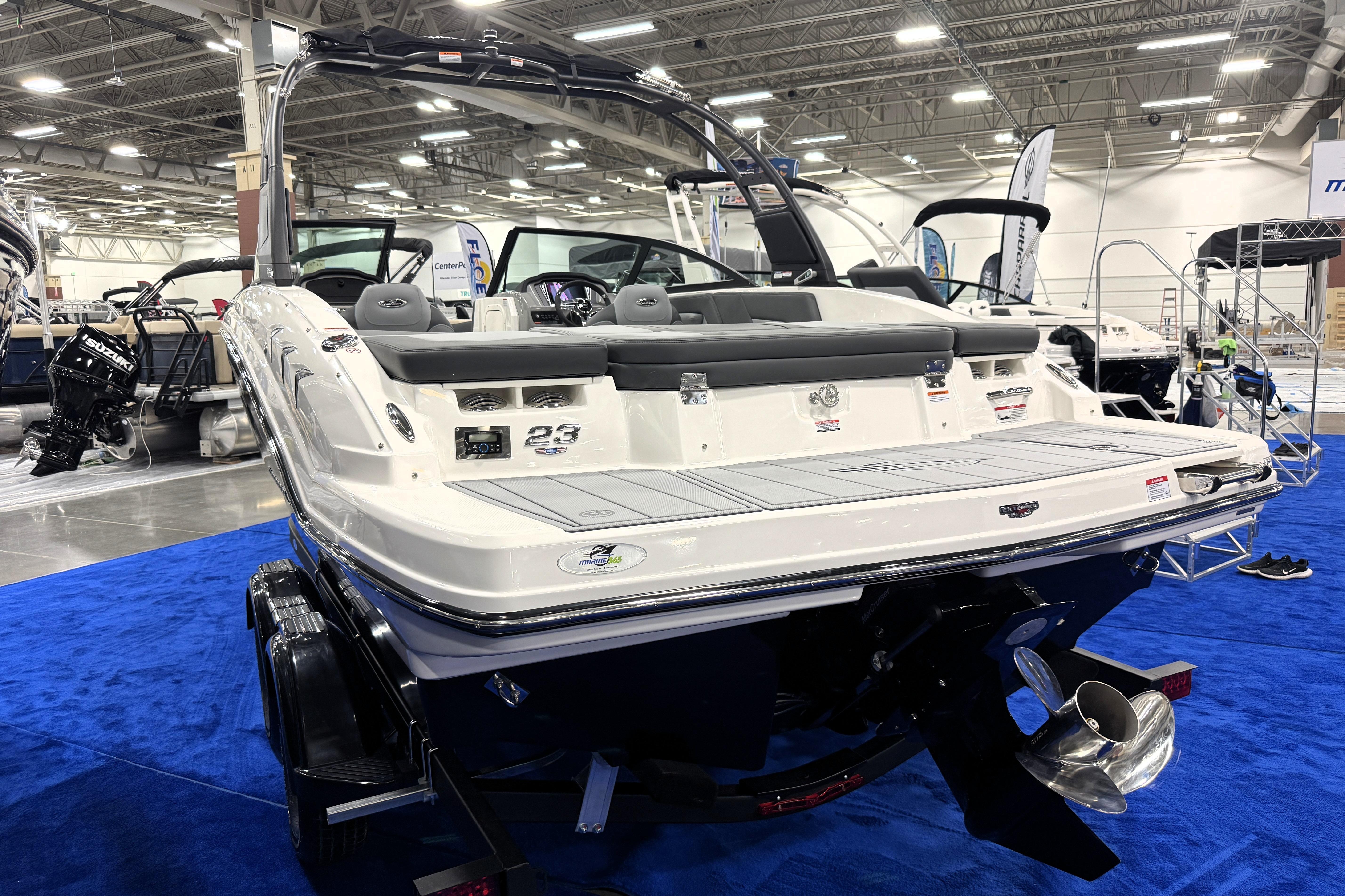 2026 Chaparral 23 SSi boat displayed indoors on blue carpet.