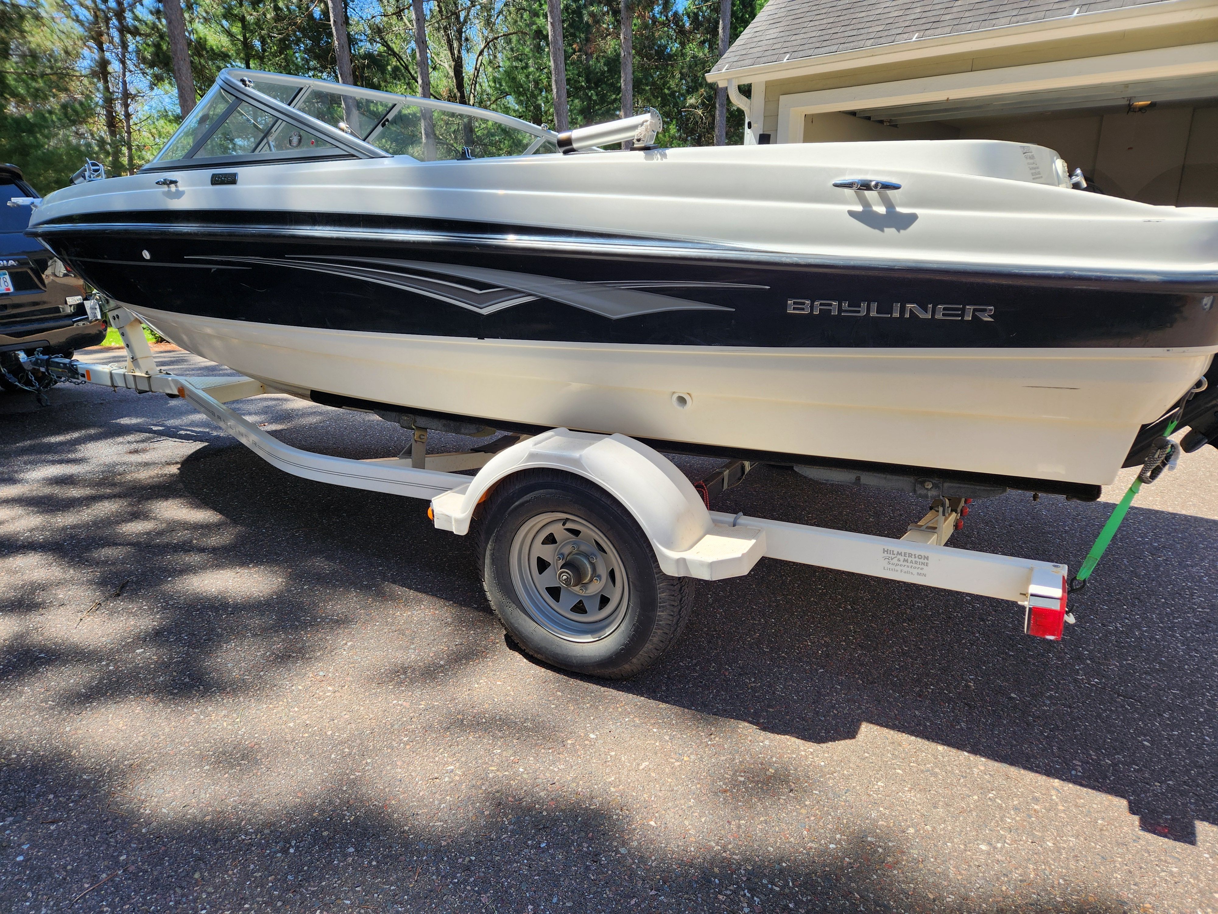 2009 Bayliner 194SF on a trailer in a driveway.