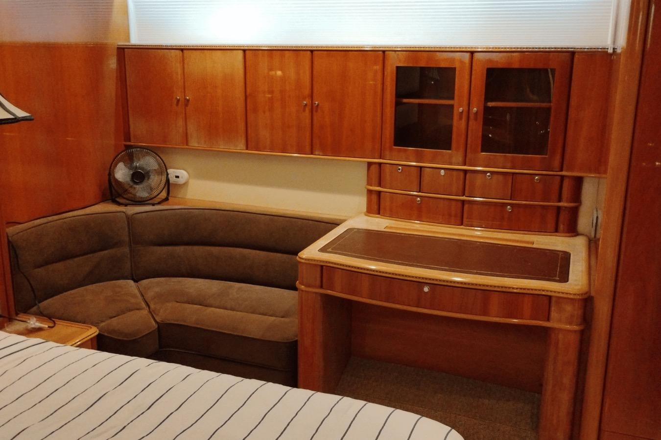 Luxurious wooden interior of a 2001 Viking Princess 72 yacht with cozy seating and cabinetry.