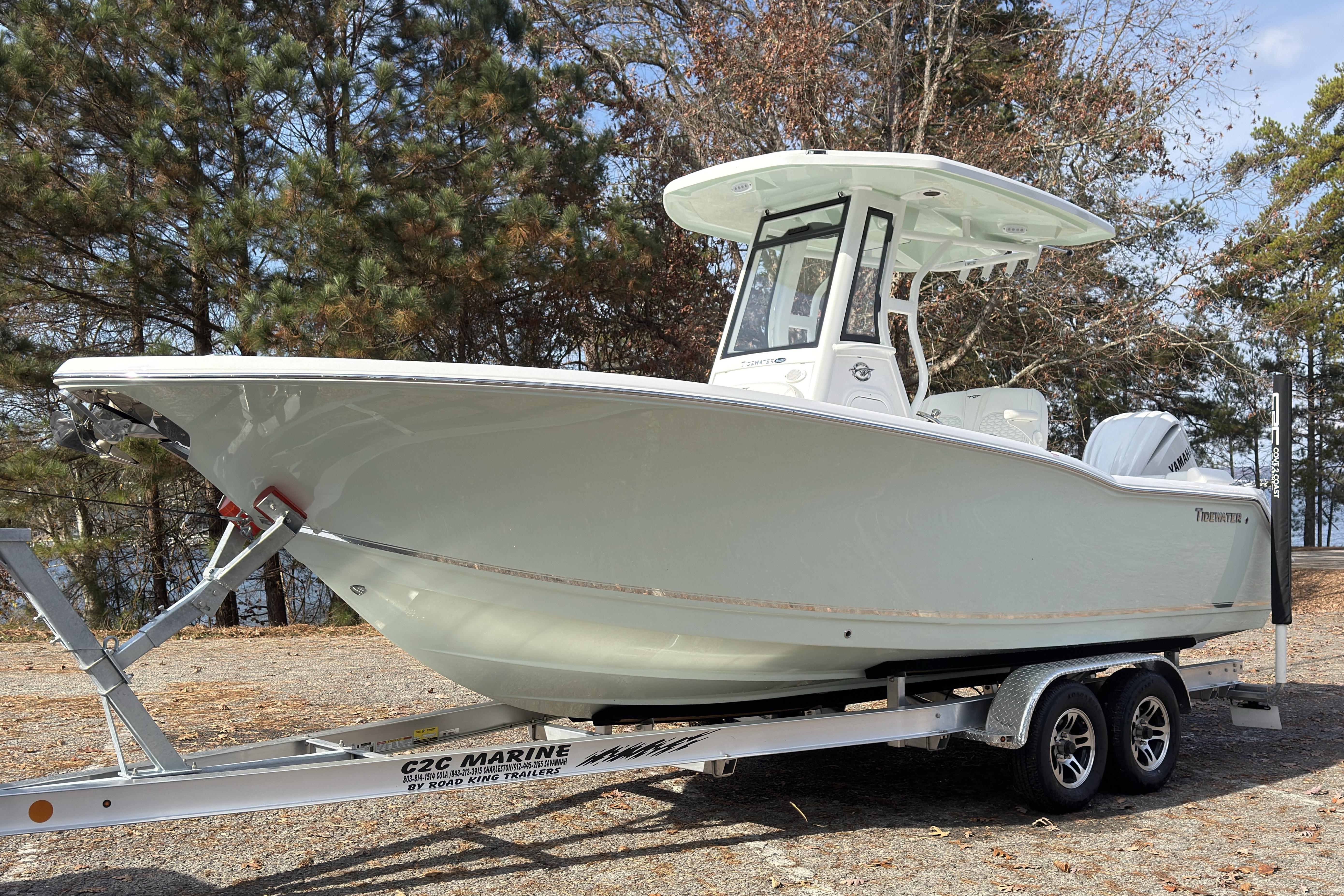 2026 Tidewater 232 LXF boat on trailer, surrounded by trees.