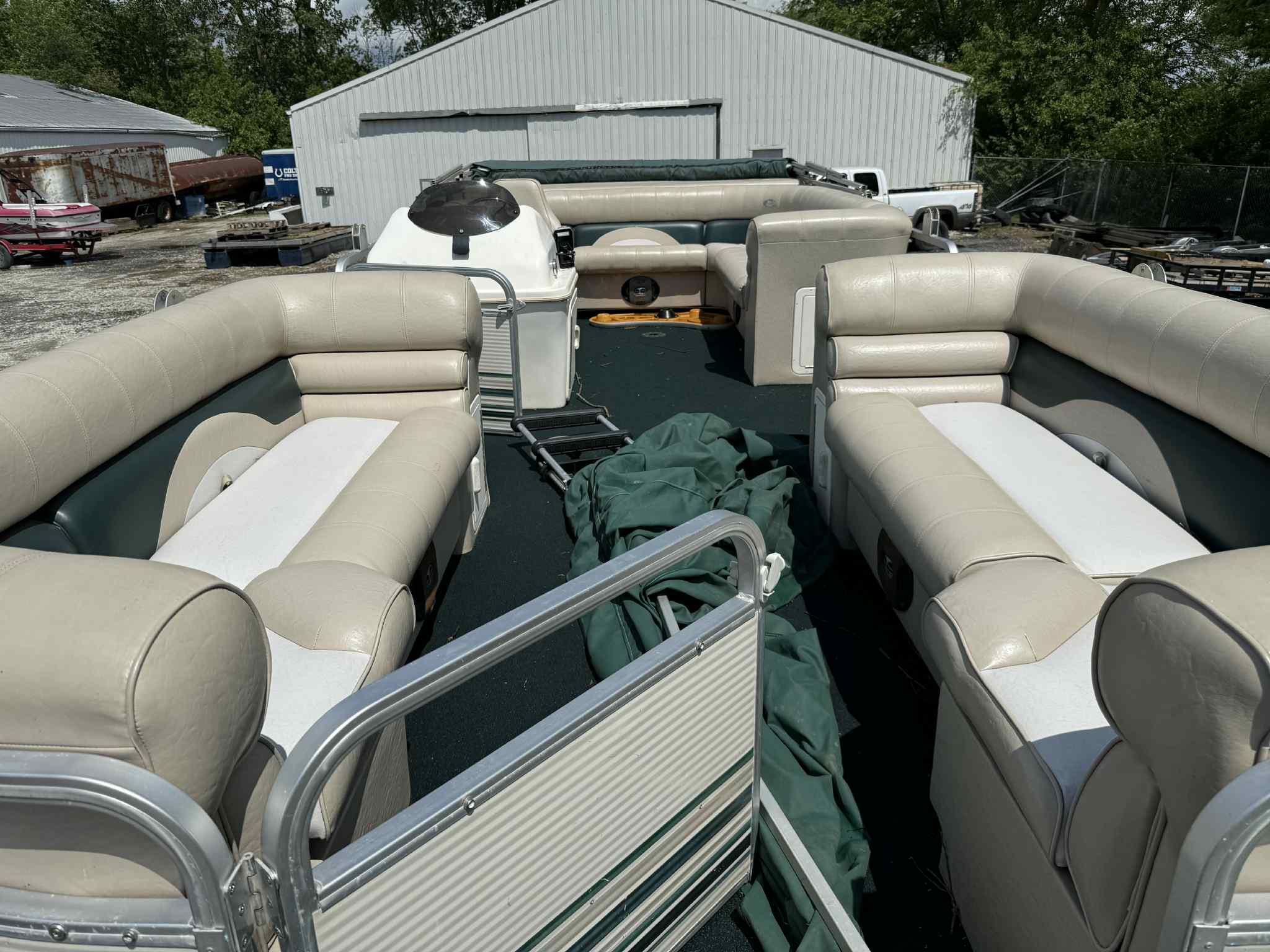 1999 Smoker Craft 8526 Pleasure Isle I/O pontoon boat with spacious seating and green cover.