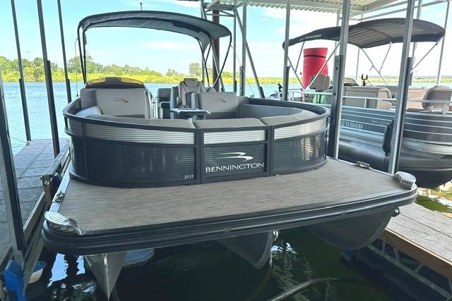 2021 Bennington L Bowrider 25 Quad Bench pontoon boat docked on a sunny day.