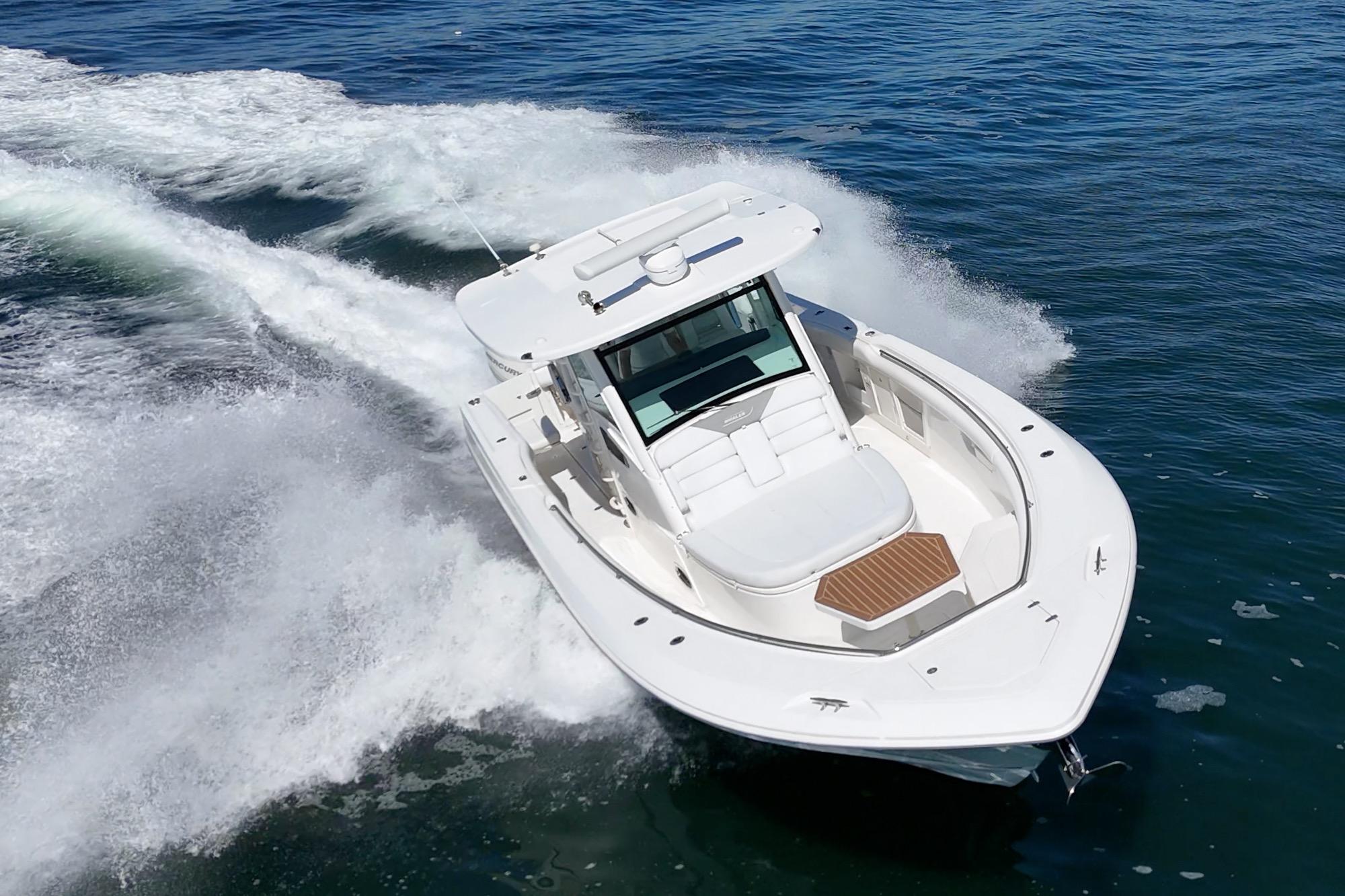 2015 Boston Whaler 370 Outrage cruising on open water, creating a dynamic wake.