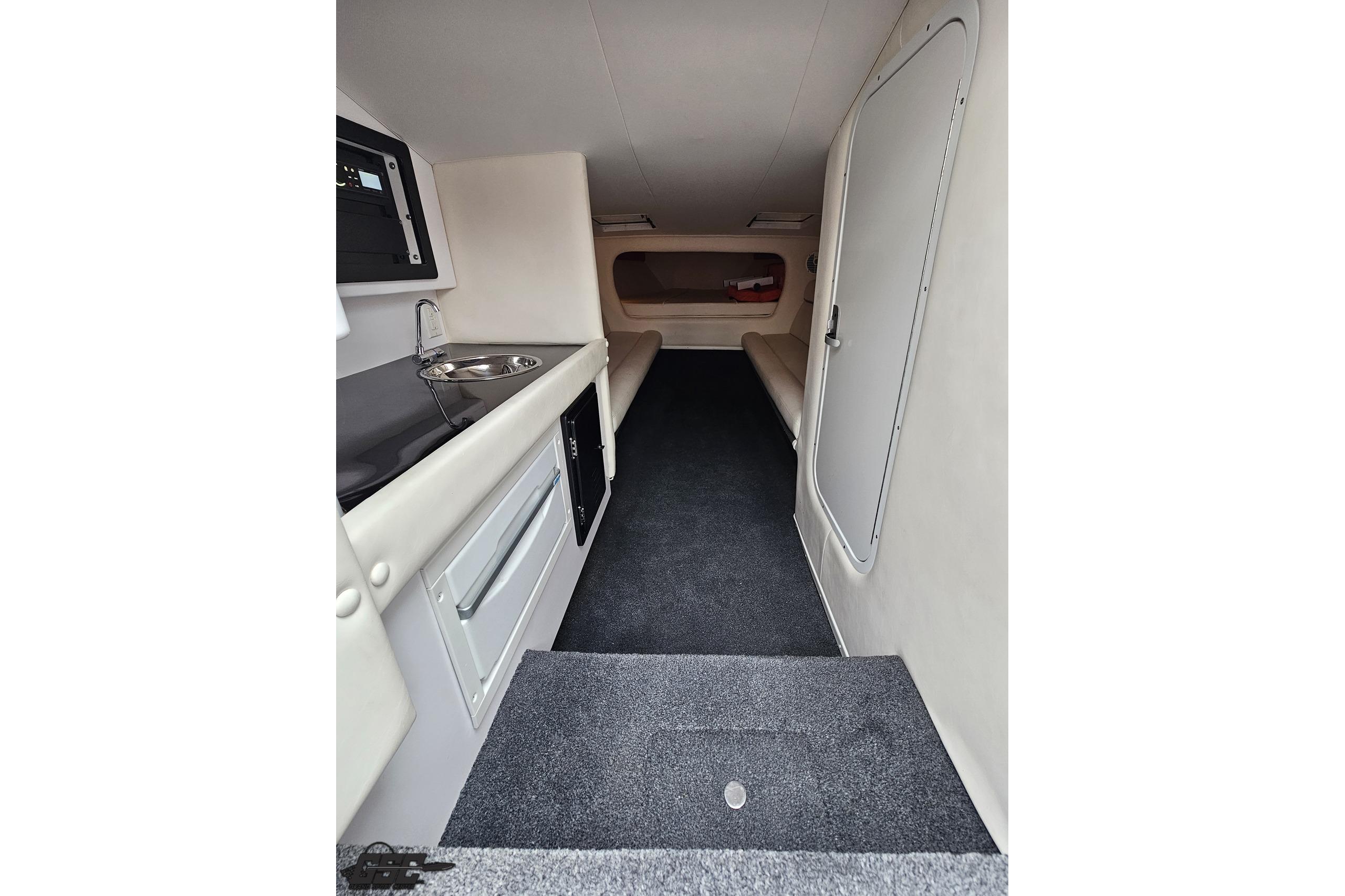 Interior of 2008 Donzi 38 ZR boat, featuring compact cabin with seating and kitchenette.