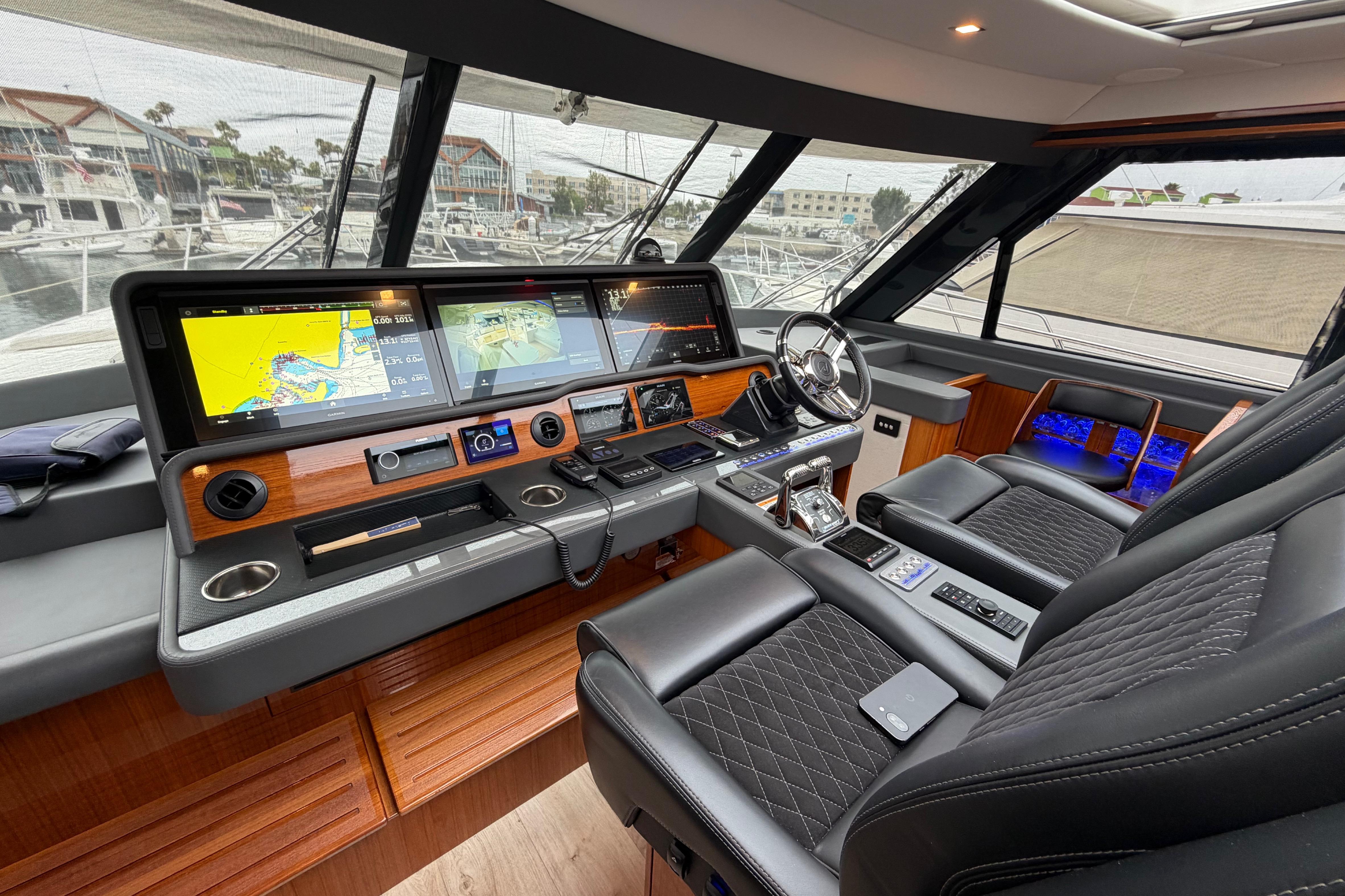 Luxurious 2023 Riviera 645 SUV yacht cockpit with advanced navigation displays and plush seating.