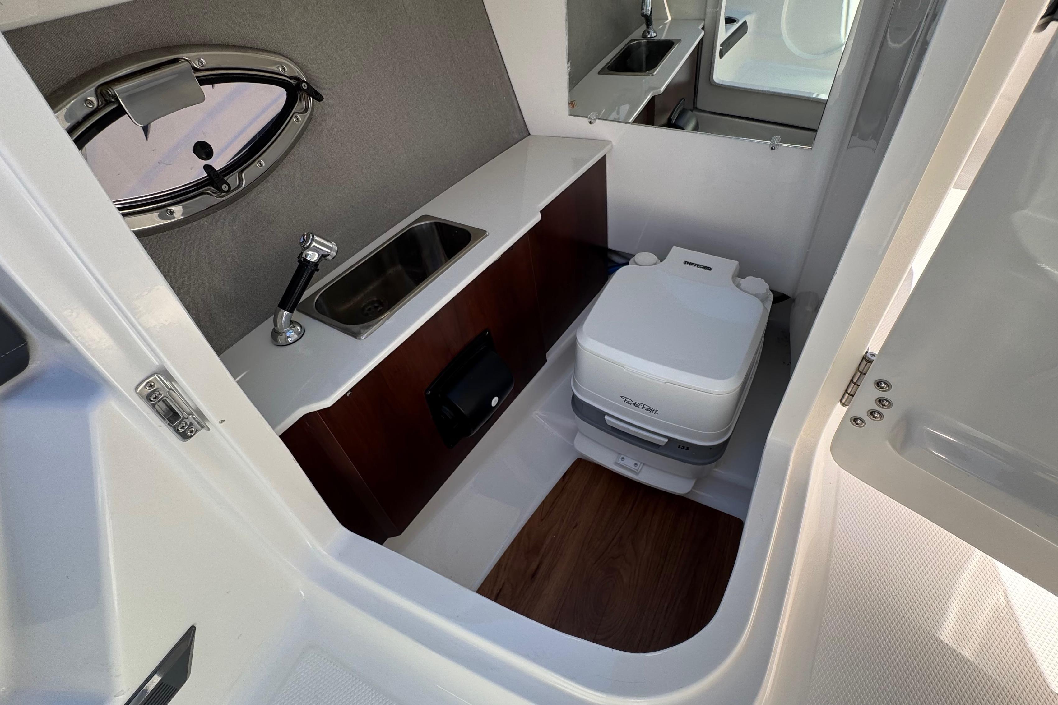 Interior of 2026 Chaparral SSX 4 boat featuring compact bathroom with sink and toilet.