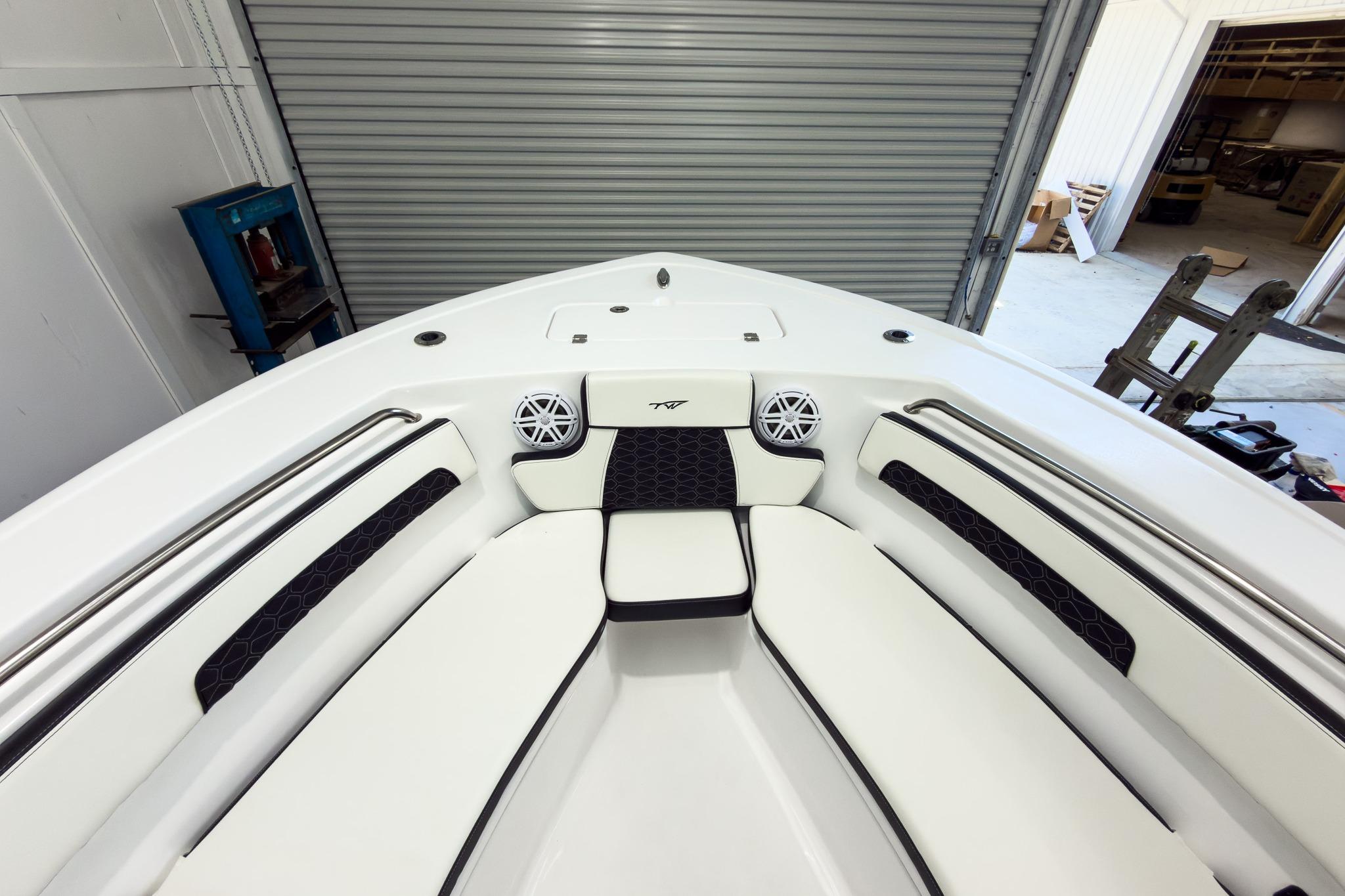 The image shows the bow of a Tidewater 220 LXF boat with white upholstery and speakers.